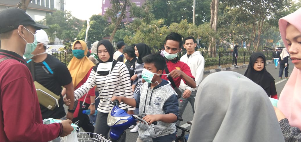 Relawan membagikan masker kepada masyarakat untuk melindungi agar tidak menghirup udara tidak sehat di Pekanbaru, Minggu (4/8). 