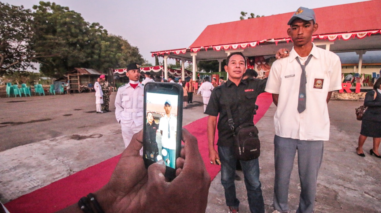 Seorang warga berfoto bersama Kristoforus Sina, siswa kelas 2 SMU yang bertinggi badan 197 cm