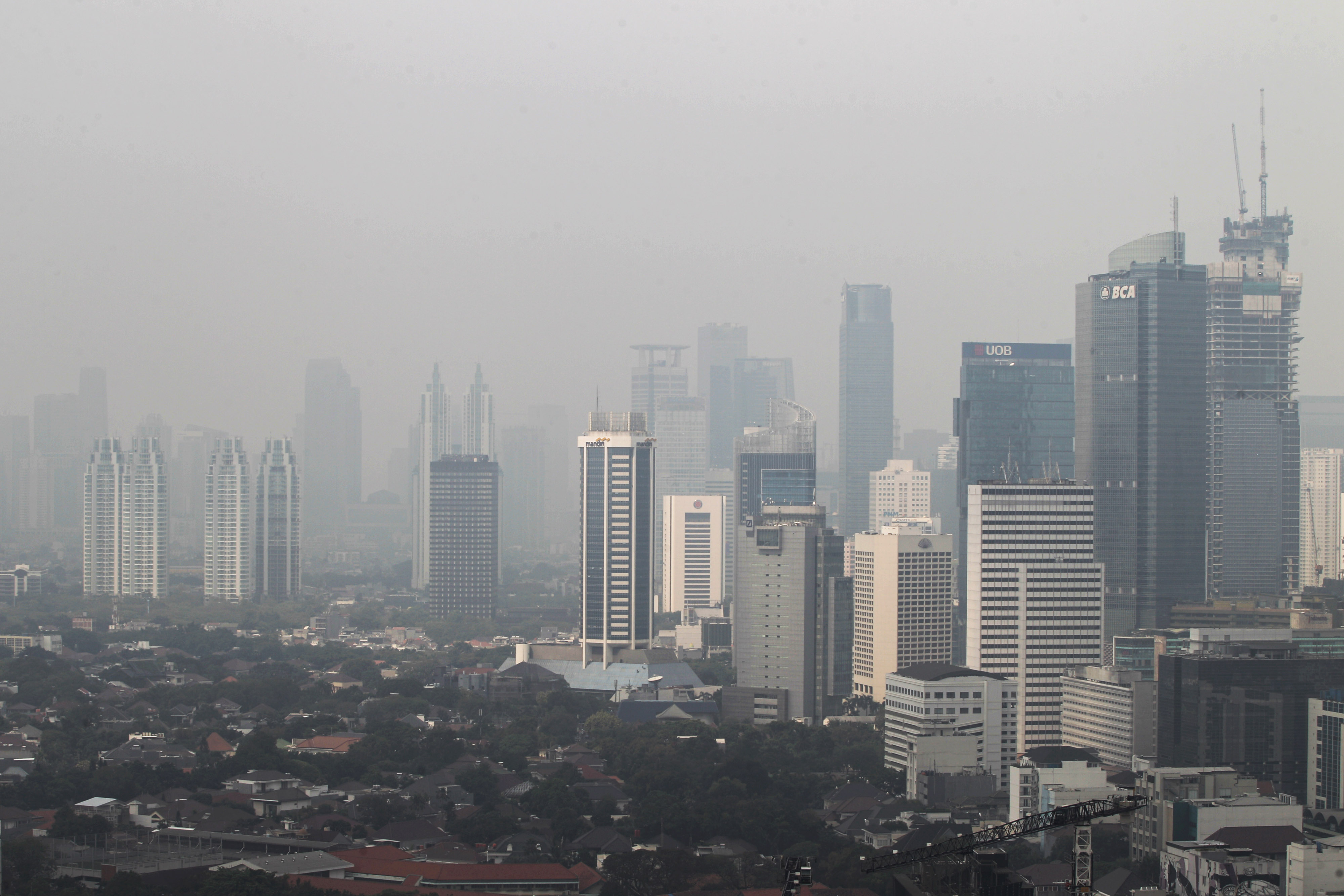 Deretan gedung bertingkat tersamar polusi udara di kawasan Jalan Thamrin, Jakarta, Senin (29/7).