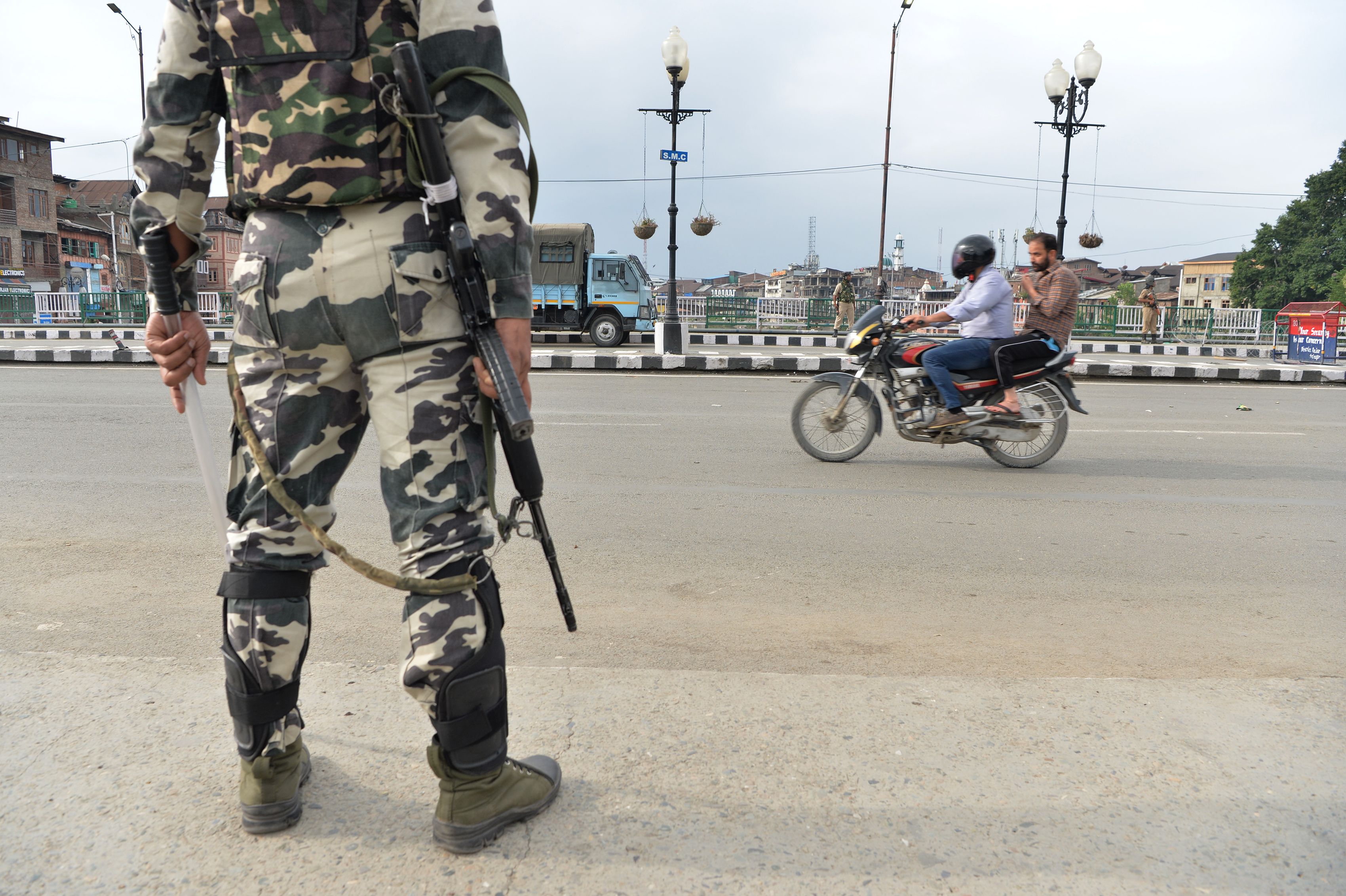 Aparat keamanan mengawasi warga di Kota Srinagar,  Jammu dan Kashmir, India setelah pencabutan status khusus.  