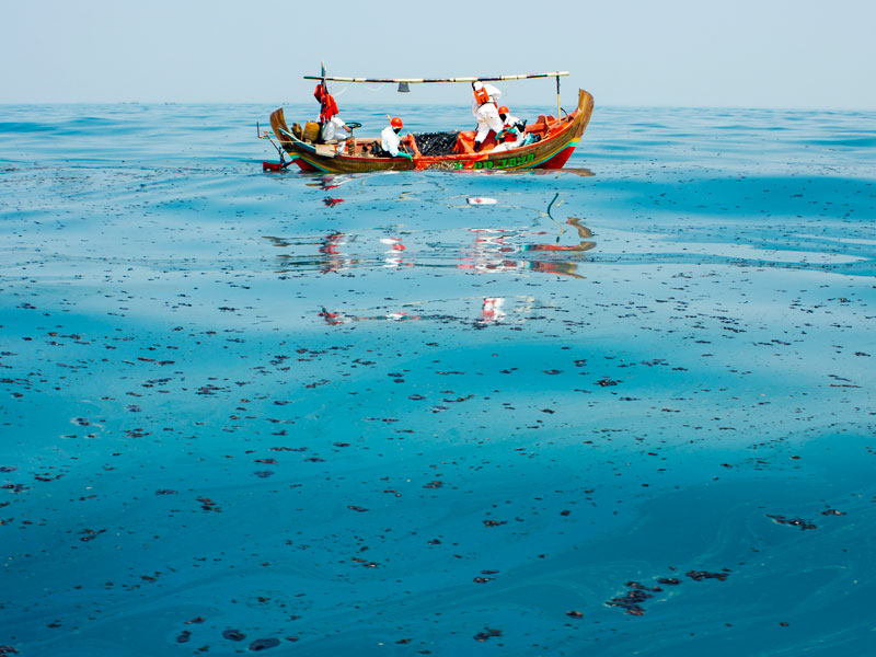 Petugas mengumpulkan tumpahan minyak mentah yang tercecer di Laut Utara Karawang, Jawa Barat.