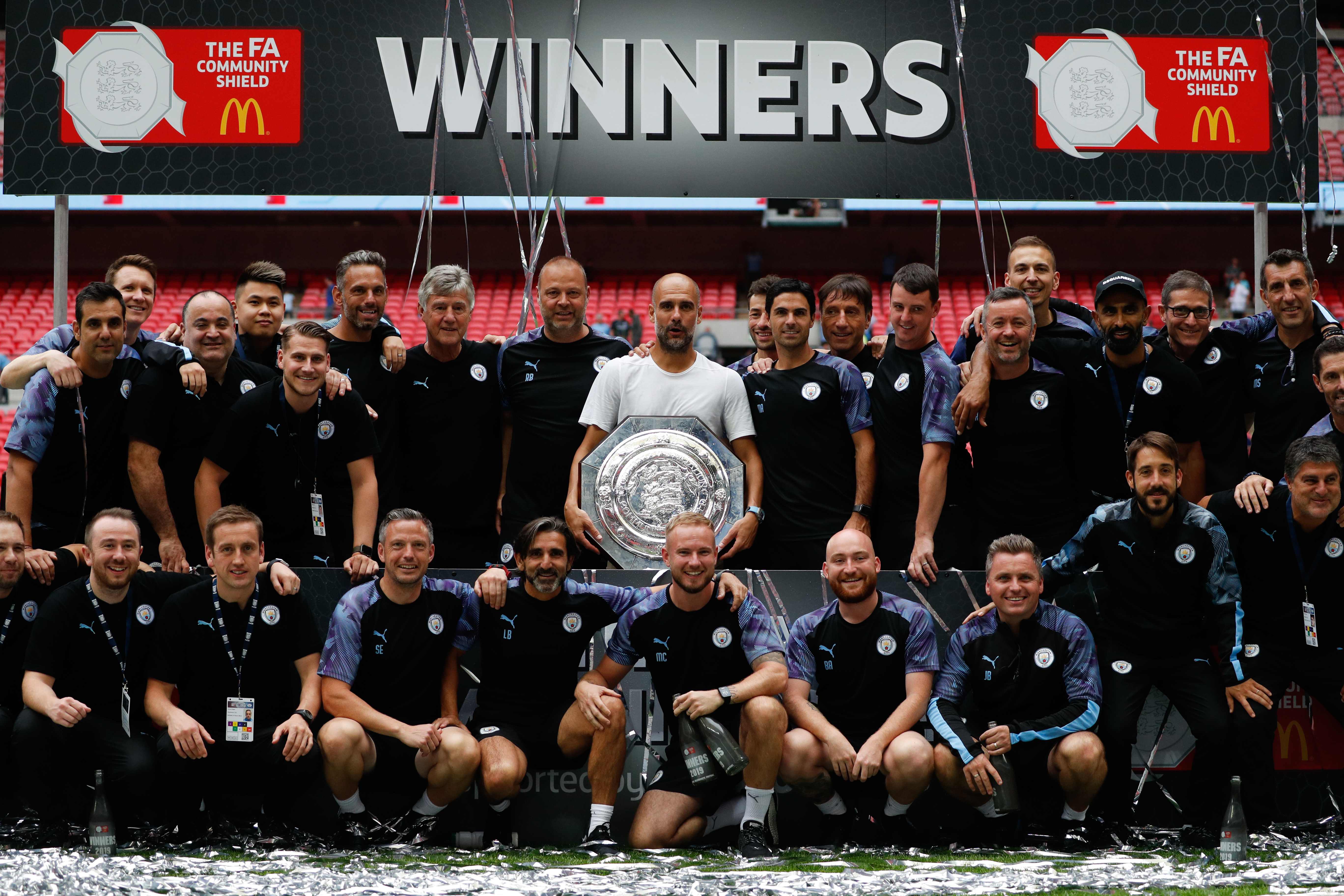 Manajer Spanyol Manchester City Pep Guardiola memegang trofi bersama timnya