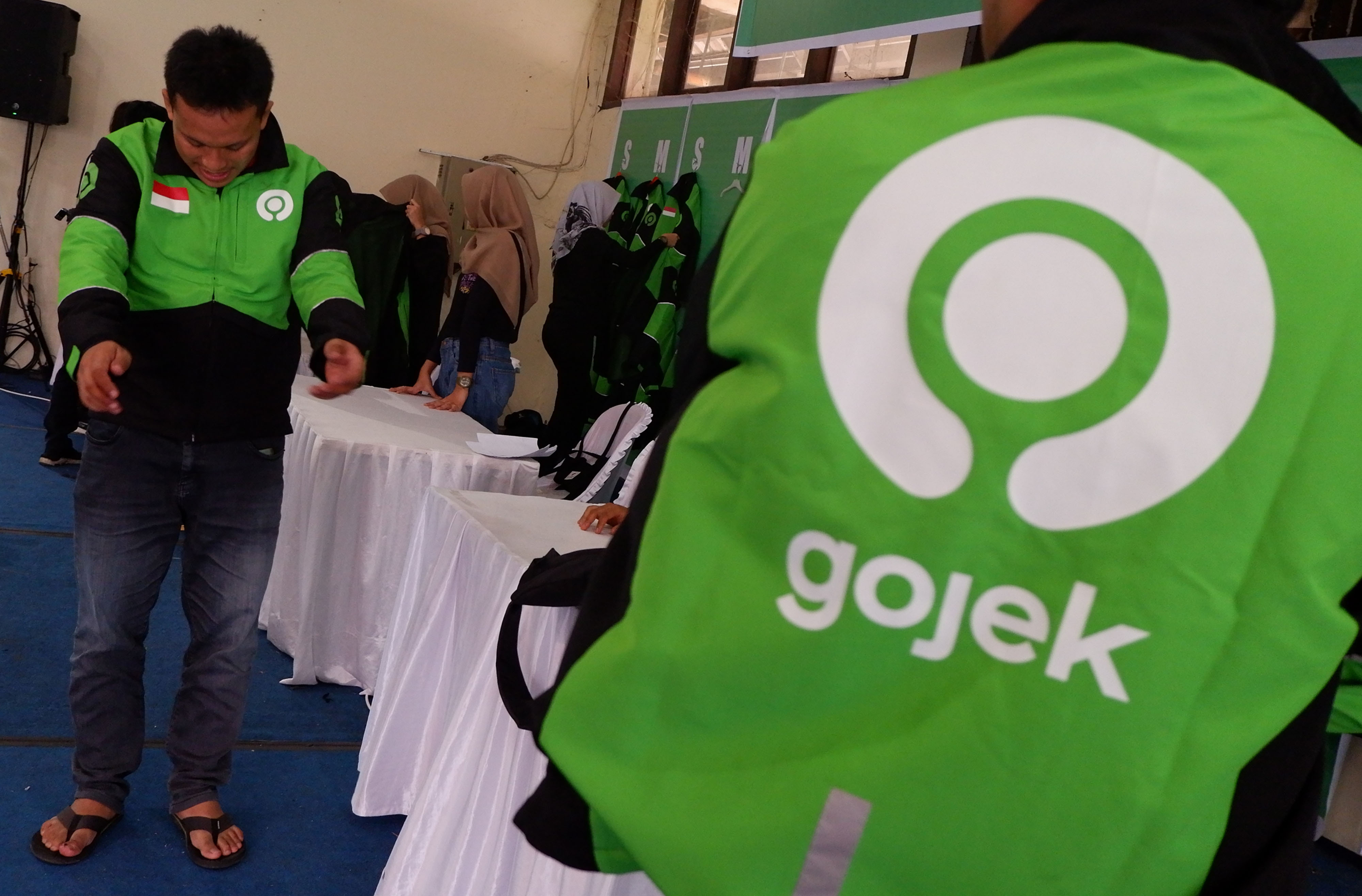 Salah seorang mitra memakai jaket berlogo baru Gojek saat diperkenalkan di Medan, Sumatra Utara, Sabtu (3/8)
