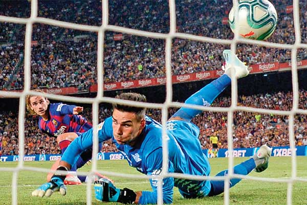 Pemain depan Barcelona asal Prancis, Antoine Griezmann (kiri), melepaskan tendangan untuk menjebol gawang Real Betis