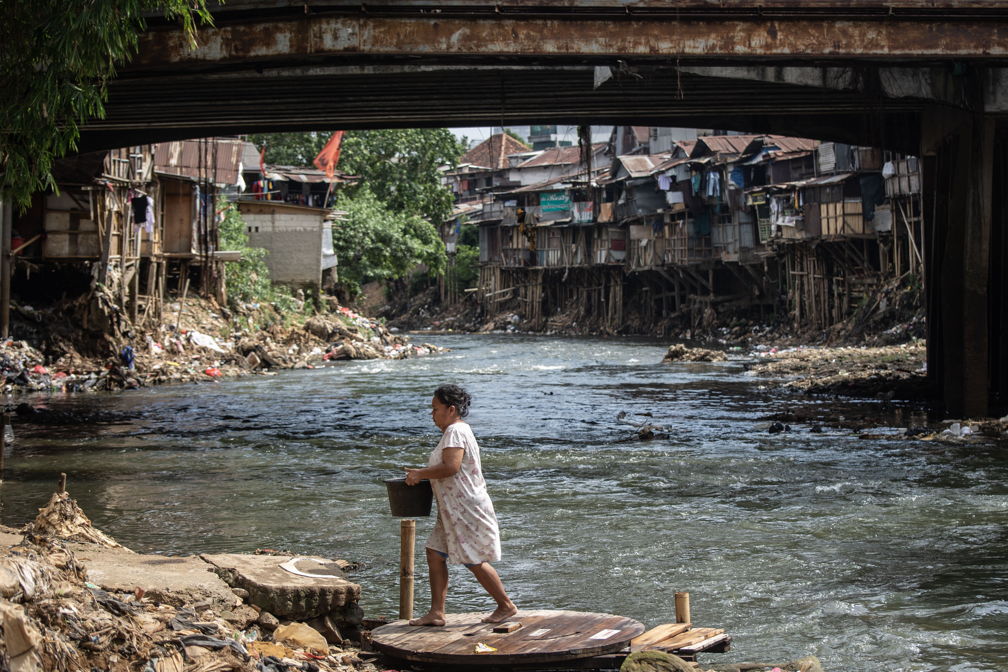 Warga beraktivitas di bantaran Sungai Ciliwung, Jakarta.