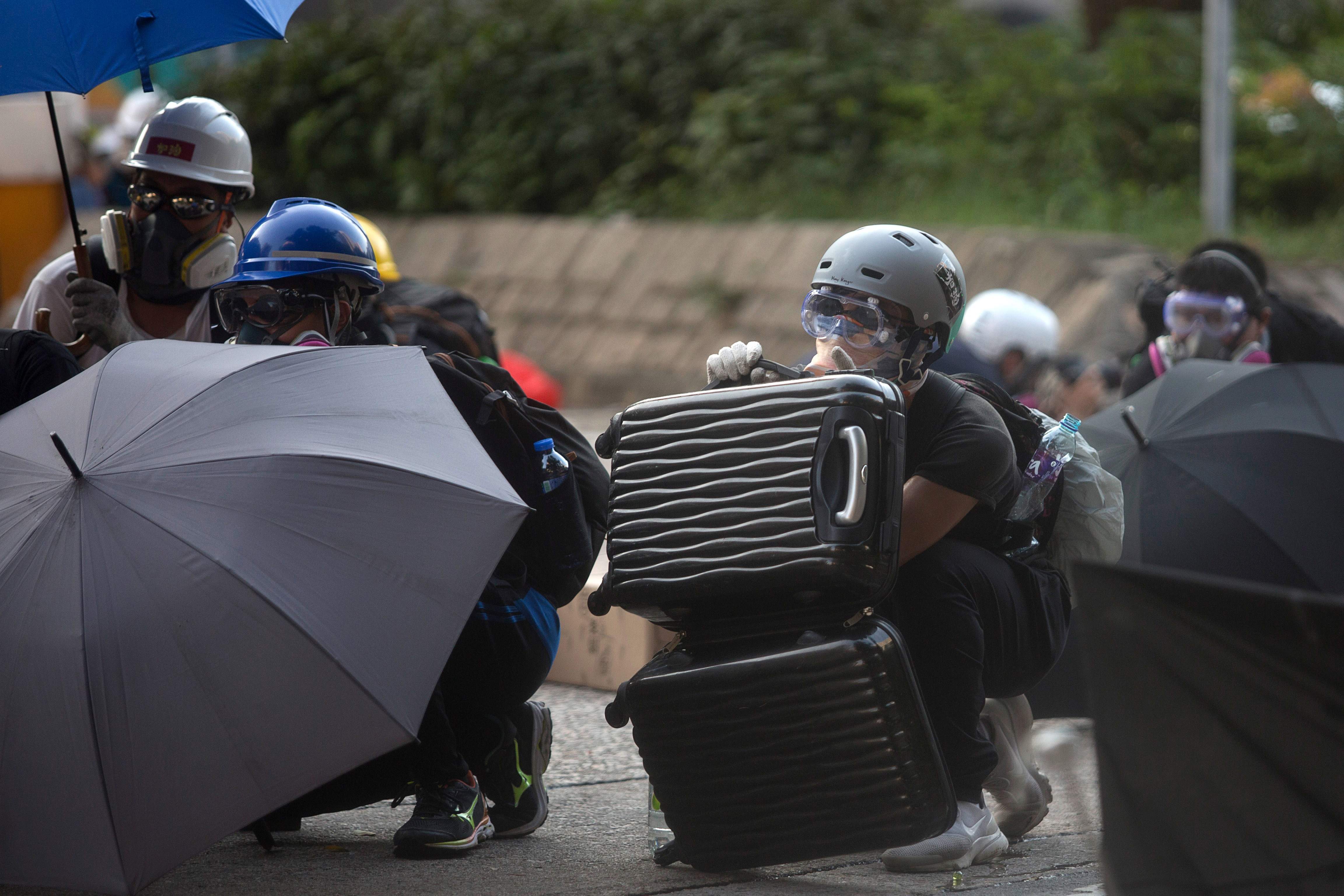 Pendemo menggunakan peralatan rumah tangga menghalau serangan aparat keamanan di Hong Kong