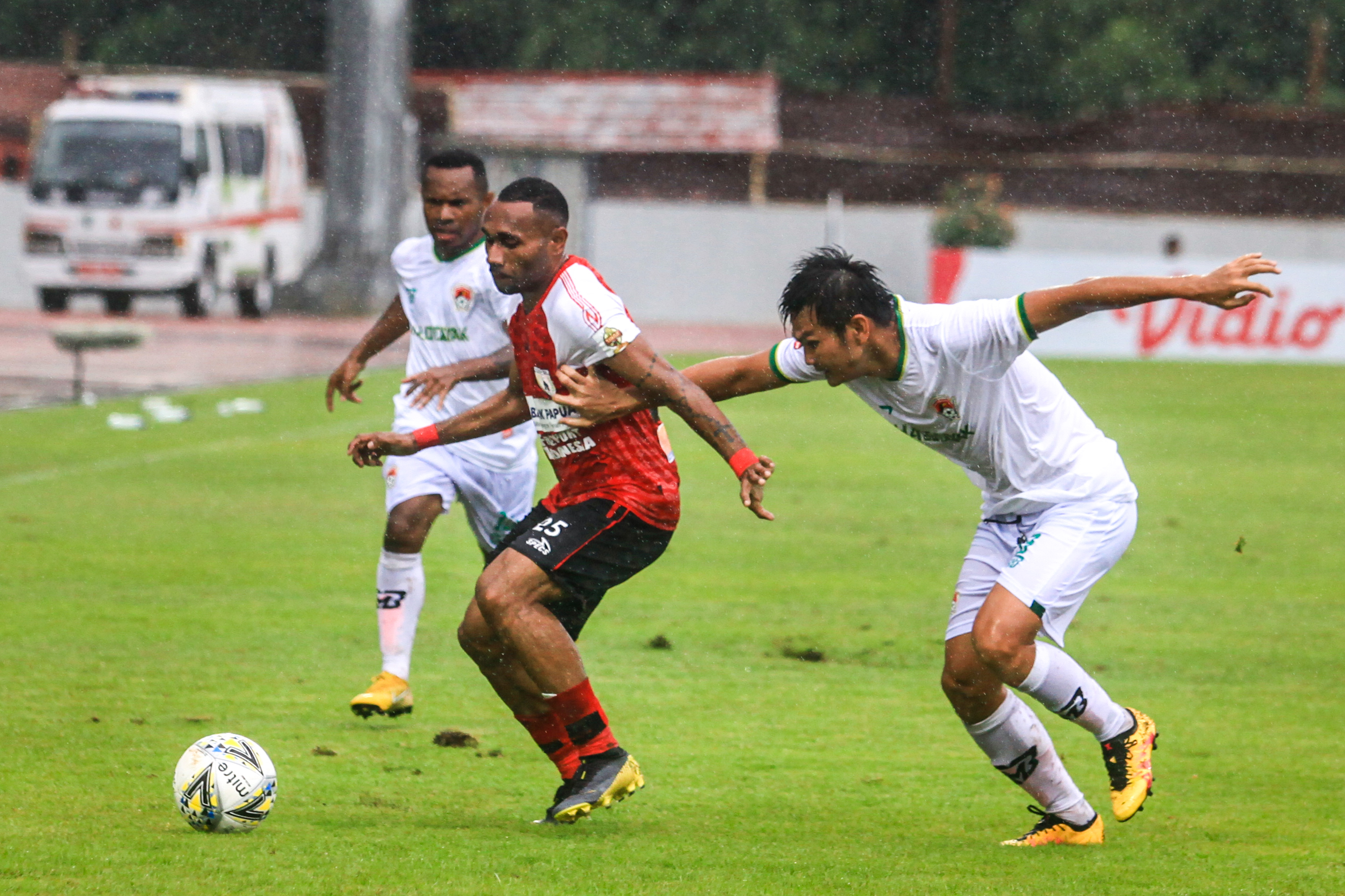  Pesepak bola Kalteng Putra FC Bobby Satria (kanan) berebut bola dengan pesepak bola Persipura Jayapura (tengah)