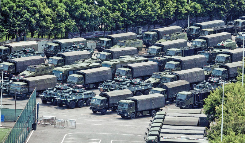 MILITER TIONGKOK BERSIAP: Truk dan kendaraan lapis baja terlihat di luar stadion Teluk Shenzhen di Shenzhen yang berbatasan dengan Hong Kong
