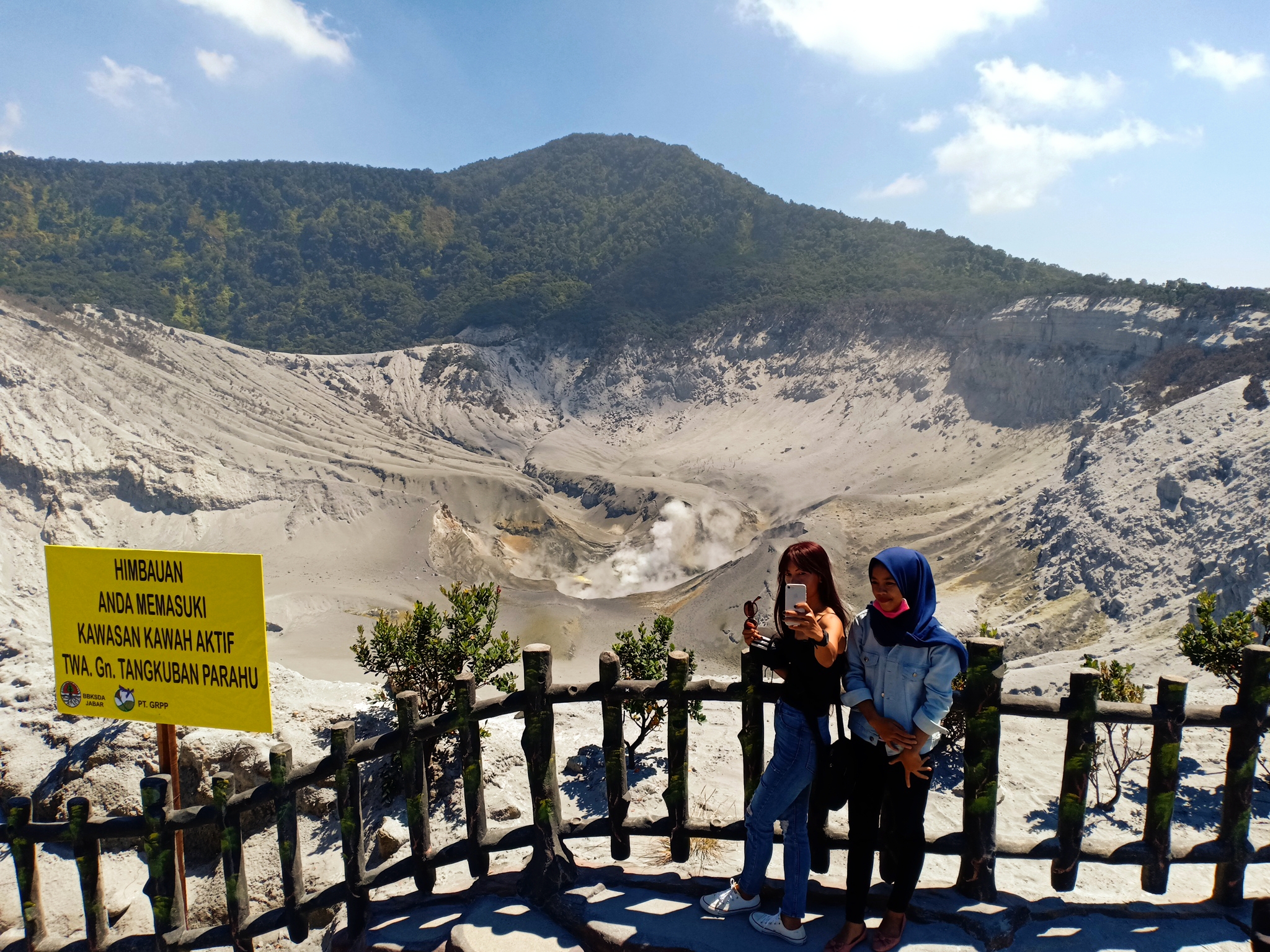 Pengunjung swafoto dengan latar belakang Kawah Ratu Gunung Tangkuban Parahu, Kamis (1/8).