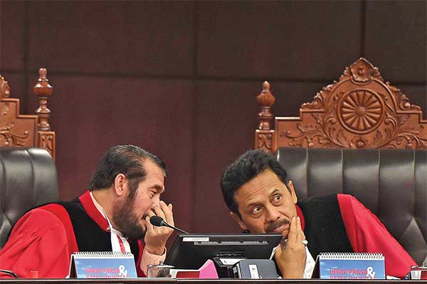 Ketua Mahkamah Konstitusi (MK) sekaligus pimpinan majelis hakim MK Anwar Usman (kiri) berdiskusi dengan hakim MK I Dewa Gede Palguna