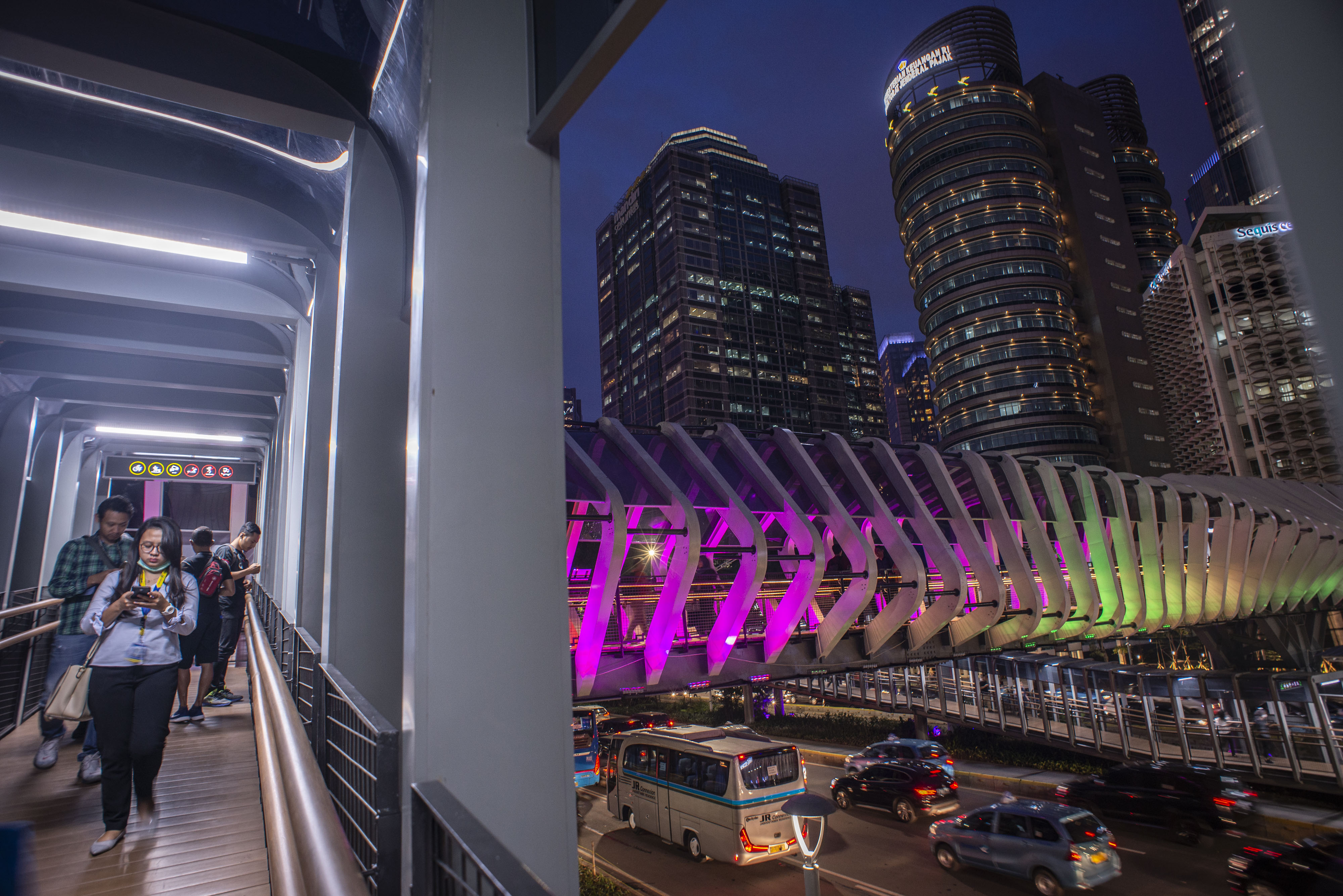 Pejalan kaki melintas di Jembatan Penyeberangan Orang (JPO) Gelora Bung Karno, Senayan, Jakarta, yang telah direvitaslisasi. 