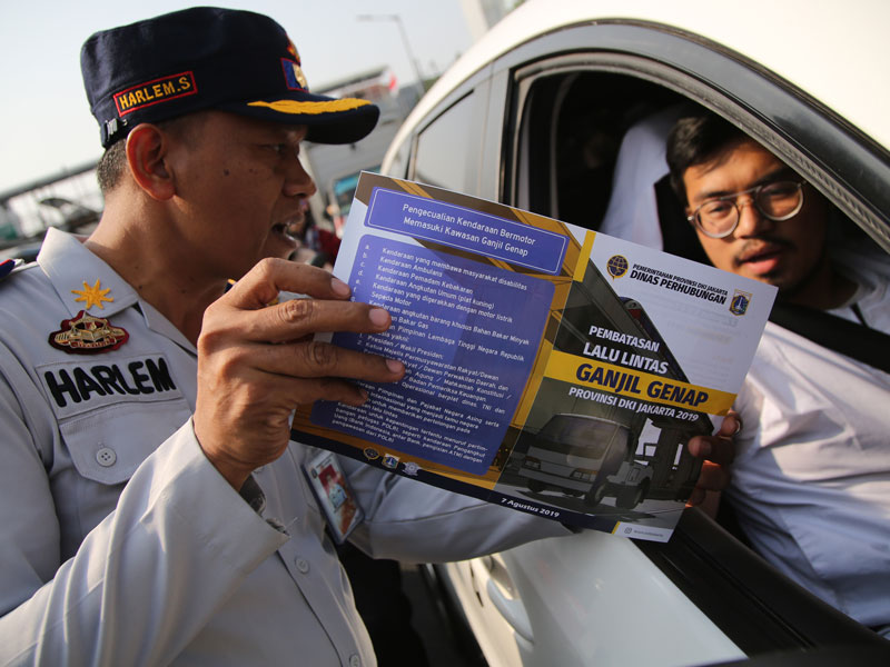 Petugas Dinas Perhubungan DKI Jakarta melakukan sosialisasi perluasan area ganjil-genap kepada pengemudi mobil di perempatan Matraman.