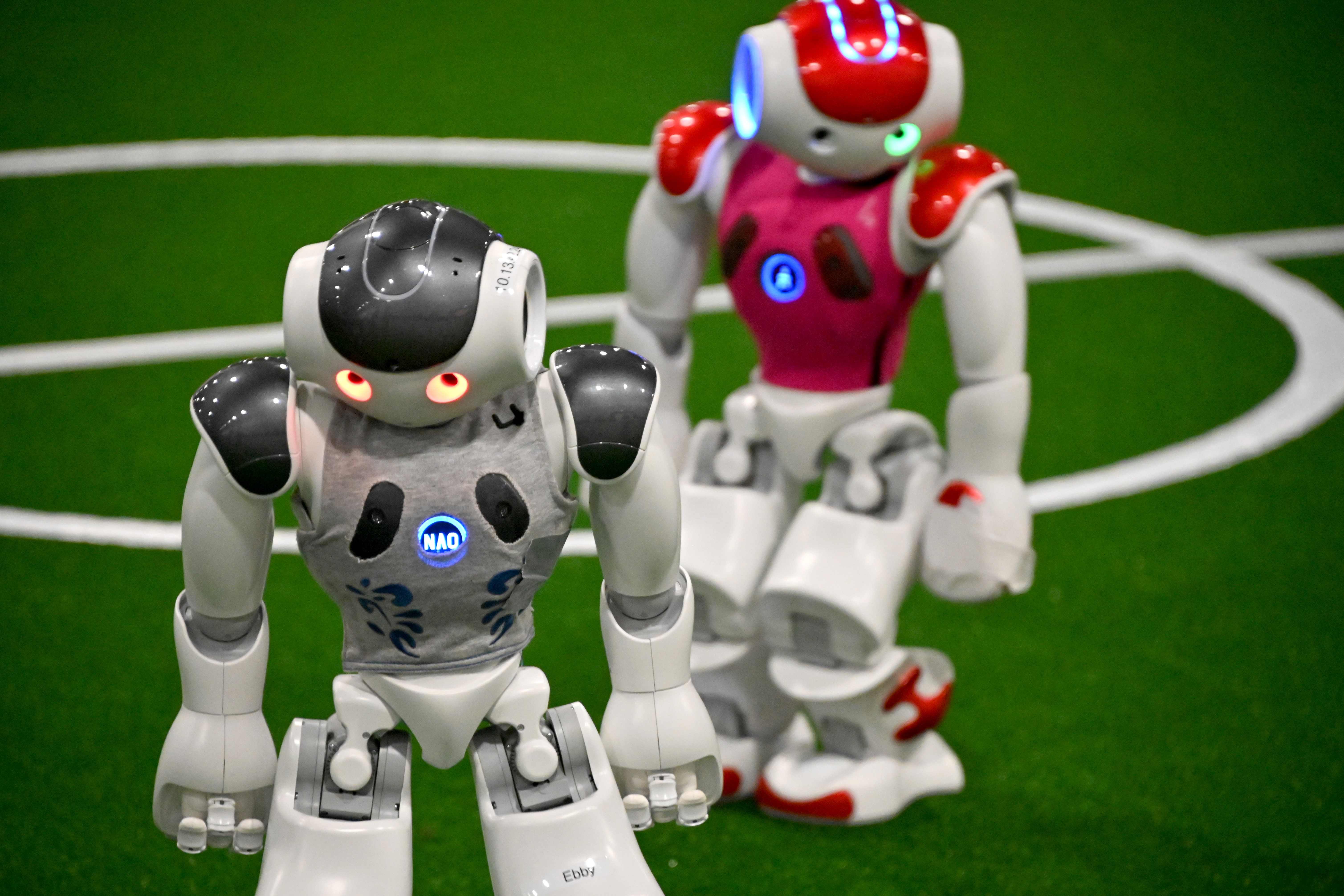 Robot-robot berwarna putih bermain sepak bola dalam RoboCup 2019 