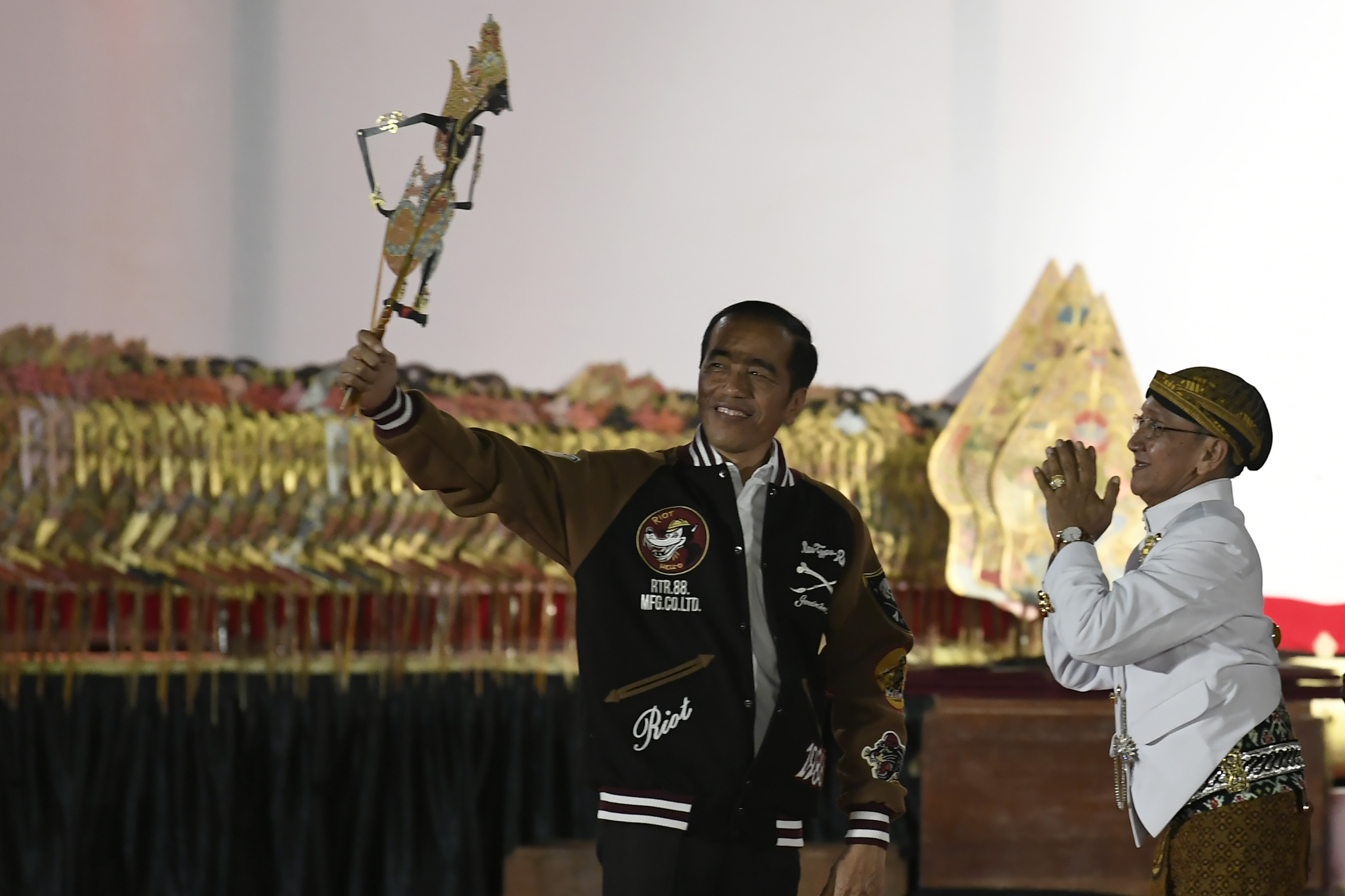 Presiden Joko Widodo (kiri) menerima wayang Kresna dari Dalang Ki Manteb Sudarsono (kanan) saat di halaman Istana Merdeka.