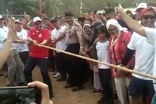 Gubernur DKI Jakarta Anies Baswedan (kaos merah bertopi putih) saat lomba tarik tambang di Jakarta Selatan, Sabtu (17/8).