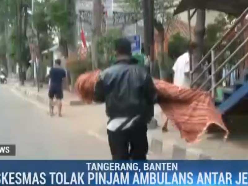 Supriadi, 40, selaku paman korban, membopong jenazah keponakannya keluar dari puskesmas. 