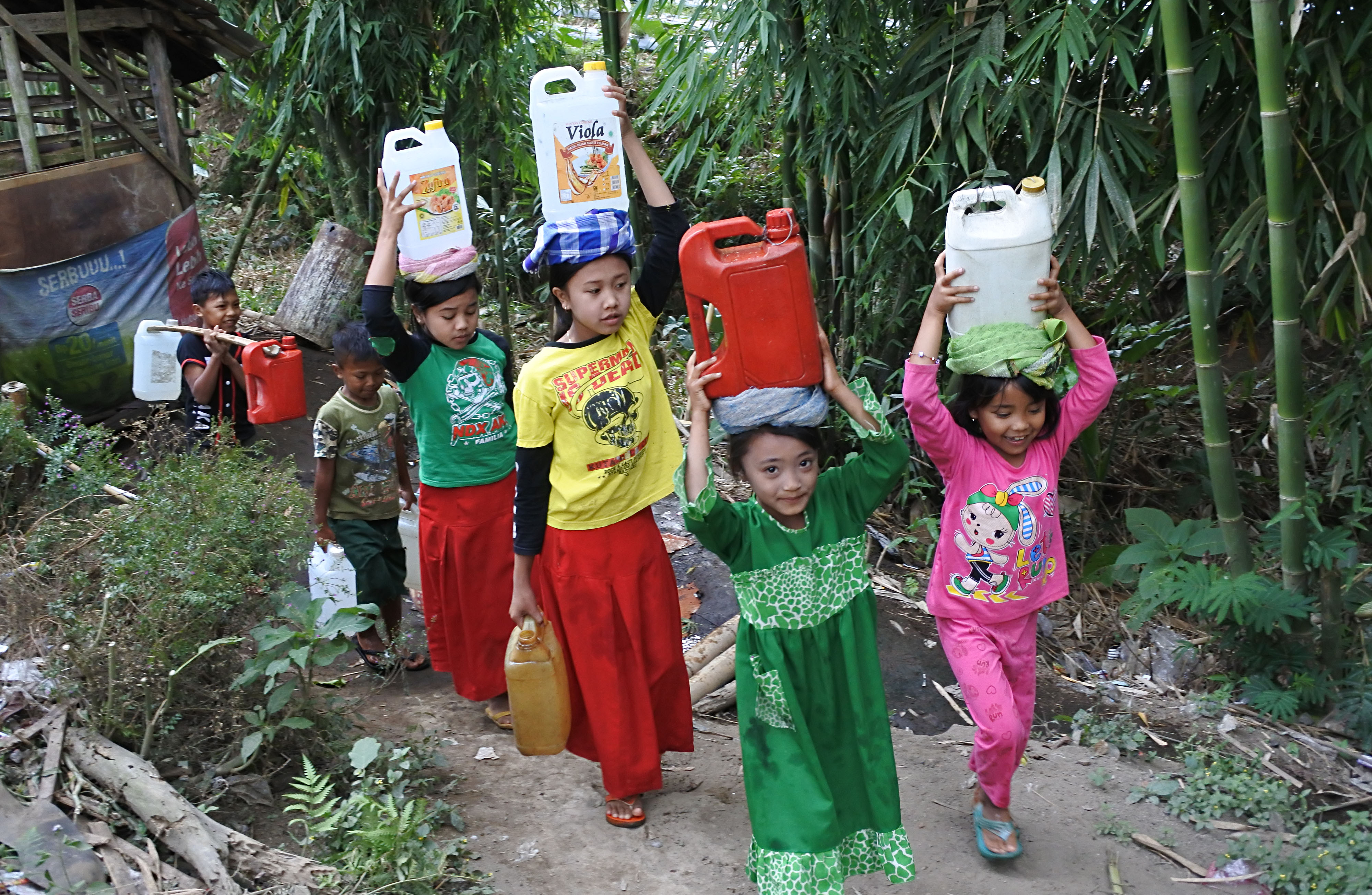 Sejumlah anak memanggul jerigen berisi air bersih di Desa Jambearum, Sumberjambe, Jember, Jawa Timur.