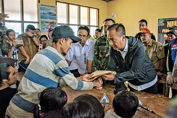 Menteri Sosial Agus Gumiwang Kertasasmita (kanan) memberikan bantuan kepada salah satu korban longsor di Desa Sirnaresmi, Cisolok