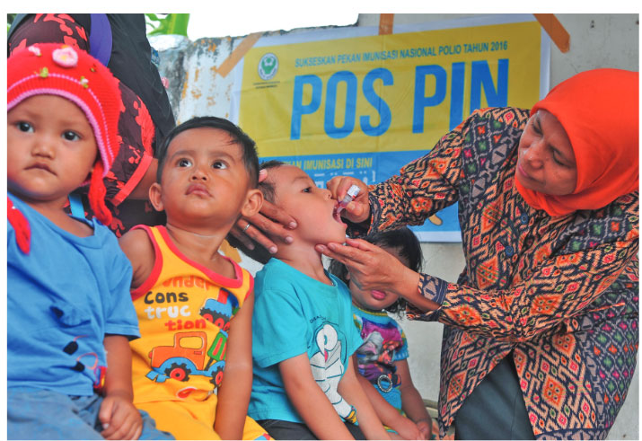 BERI VAKSINASI POLIO:  Kader Posyandu  memberikan Vaksin polio tetes  pada salah satu anak  peserta Pekan Imunisasi Nasional (PIN)  