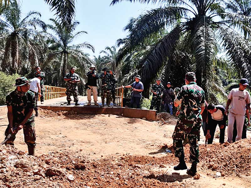 Personel TNI bersama warga bergotong royong membangun jembatan di Desa Bukit Sejahtera, Batang HarI, Sumsel, Kamis (8/8/2019)