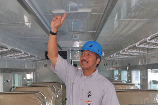Kepala Humas Industri Kereta Api (Inka) Fathor Rasid menunjukkan Kereta Api (KA) kelas ekonomi (K3) ber-AC yang sudah jadi di pabrik kereta 