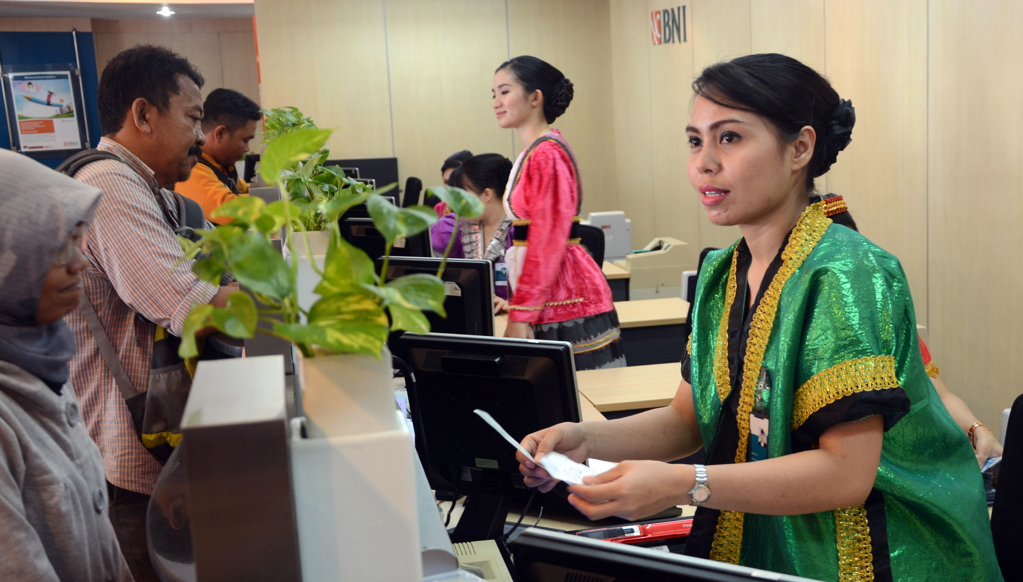  Sejumlah teller perempuan menggunakan pakai adat, melayani nasabah di Bank Negara Indonesia (BNI)