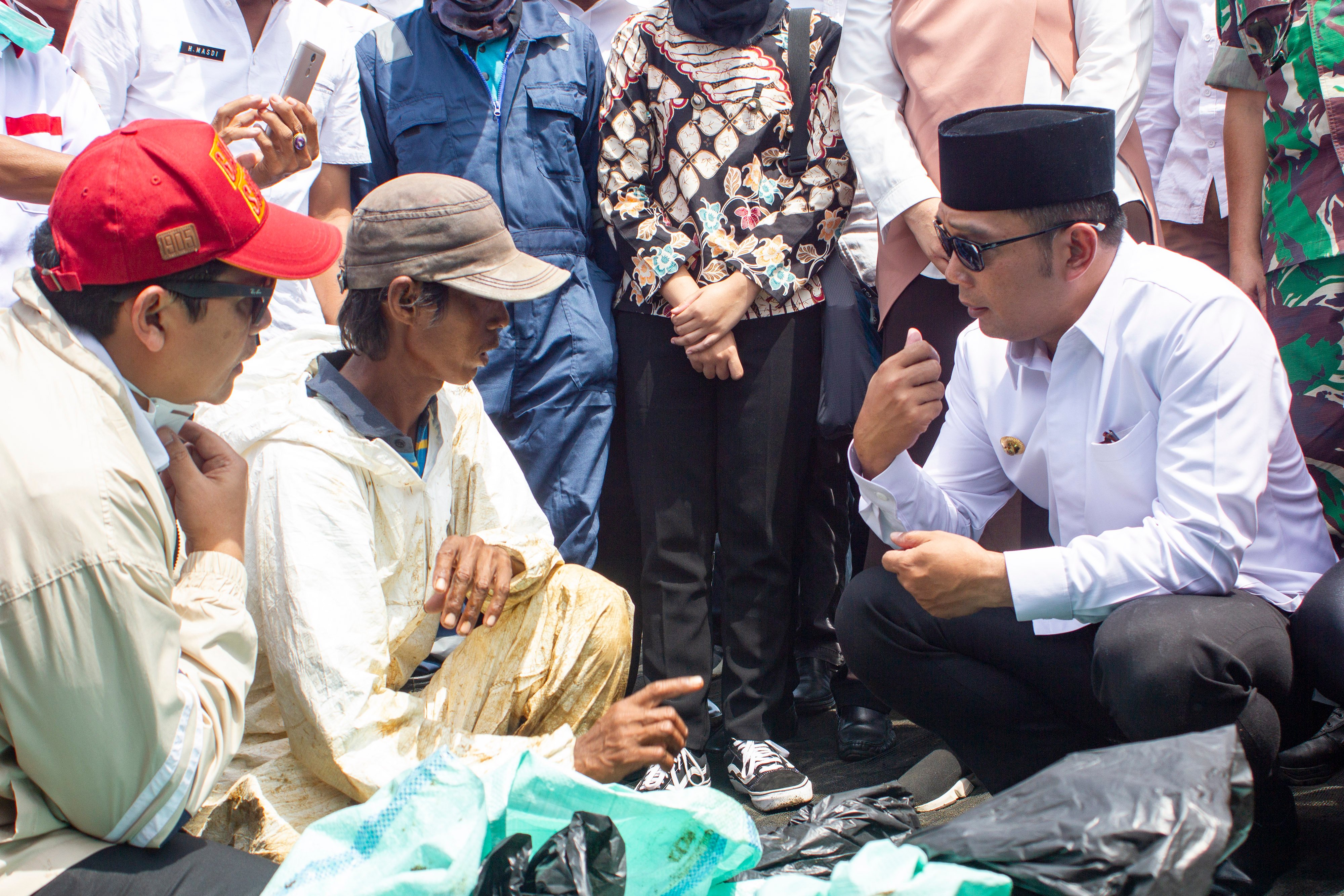 Gubernur Jawa Barat Ridwan Kamil (kanan) berdialog bersama warga yang mengumpulkan ceceran tumpahan minyak mentah saat meninjau lokasi 