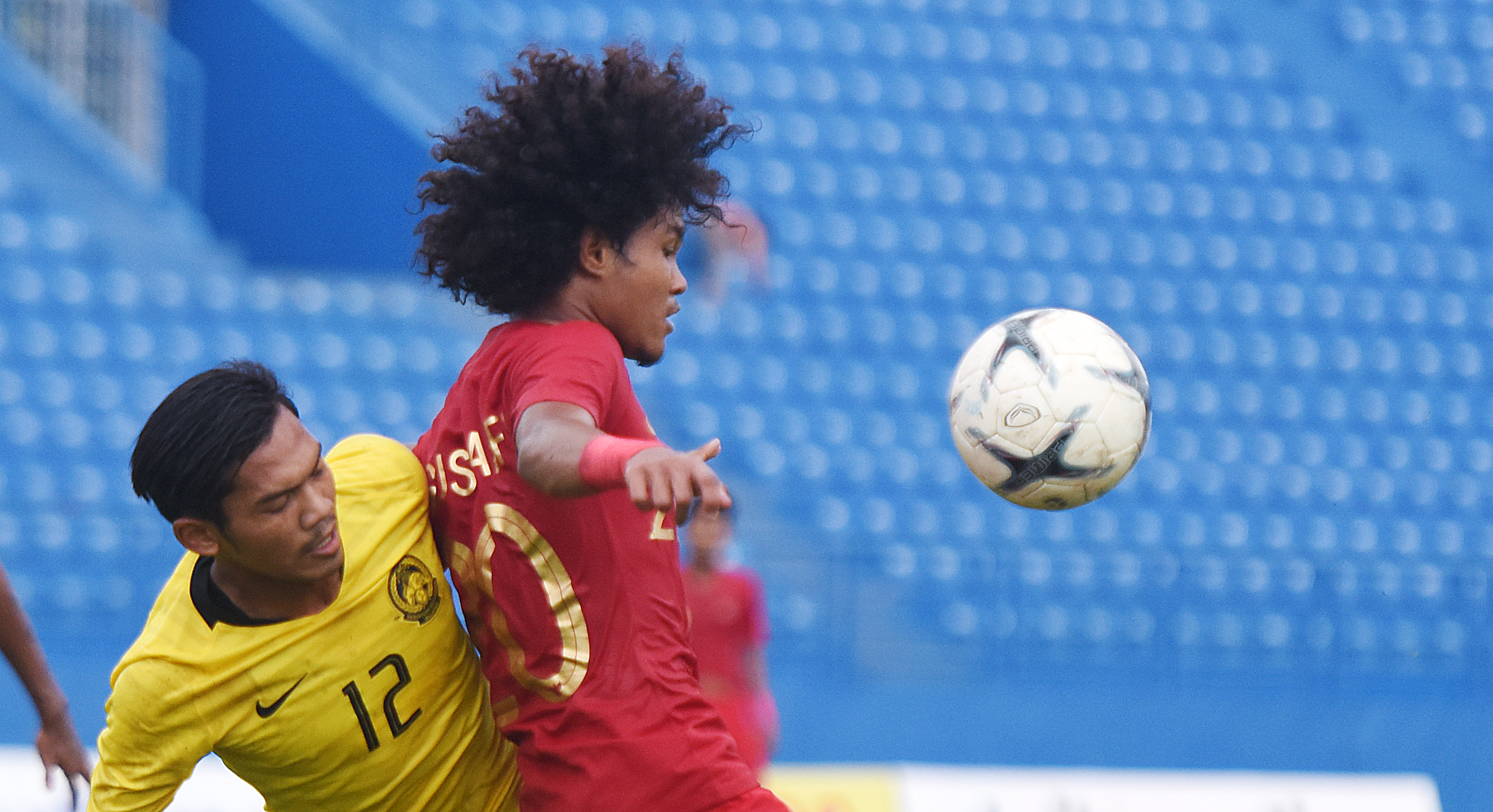 Pesepak bola Indonesia Bagus Kahfi berebut bola dengan pemain Malaysia di semifinal Piala AFF U-18