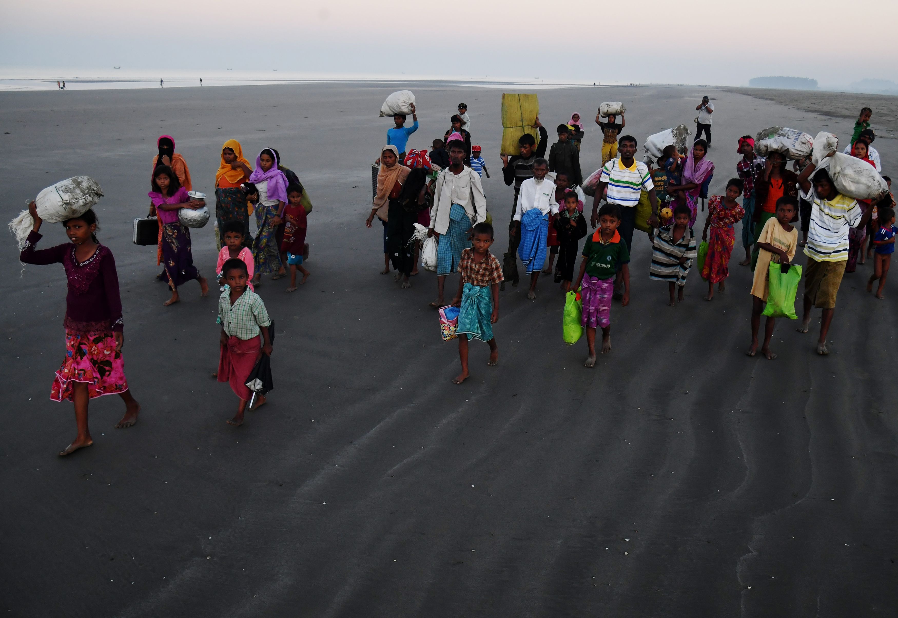 Pengungsi Rohingya berjalan menuju kamp pengungsian di Bangladesh setelah mendarat di Pantai Saplapur