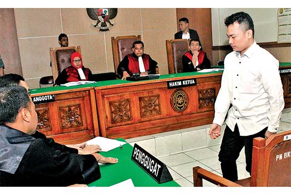 Terdakwa tindak pidana kasus pembunuhan satu keluarga, Harris Simamora (kanan)