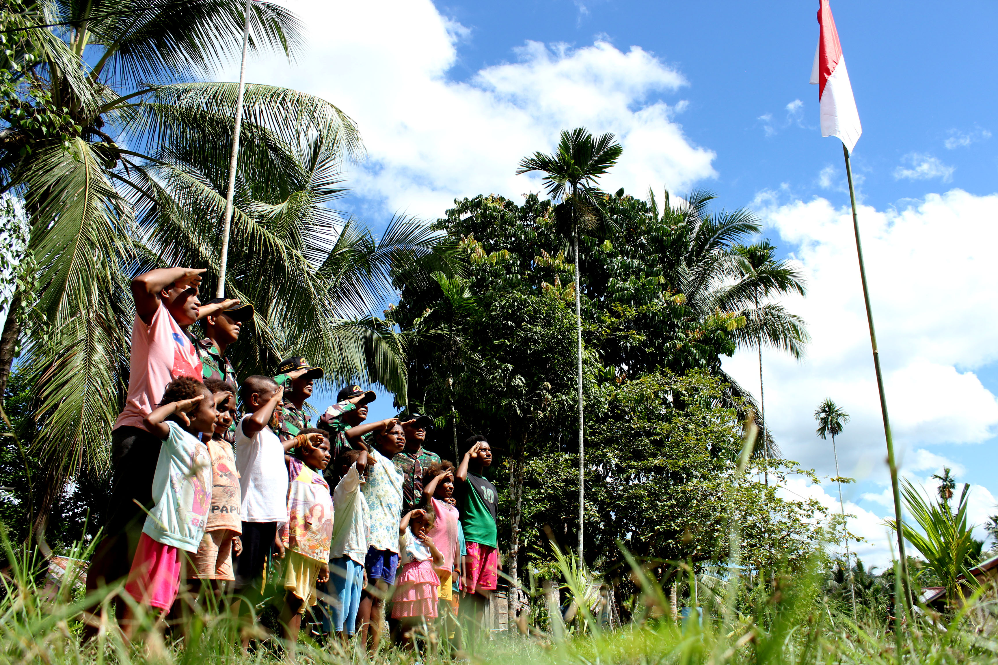 Anak-anak menghormat bendera Merah Putih di Kampung Ampas, Kabupaten Keerom, Papua, Senin (13/8). 