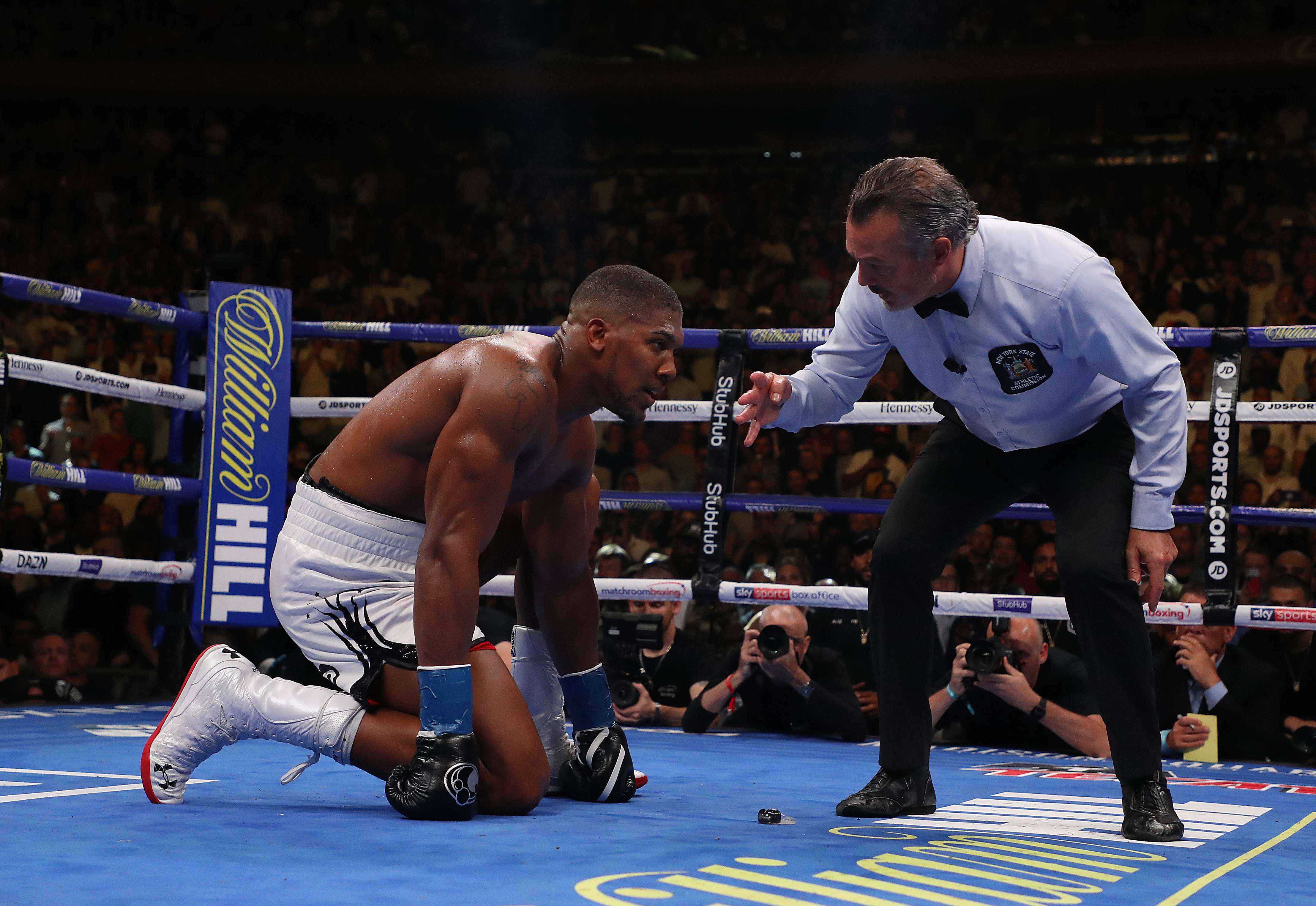 Anthony Joshua (kiri) mendapatkan hitungan dari wasit setelah terjauth dalam laga melawan Andy Ruiz Jr.