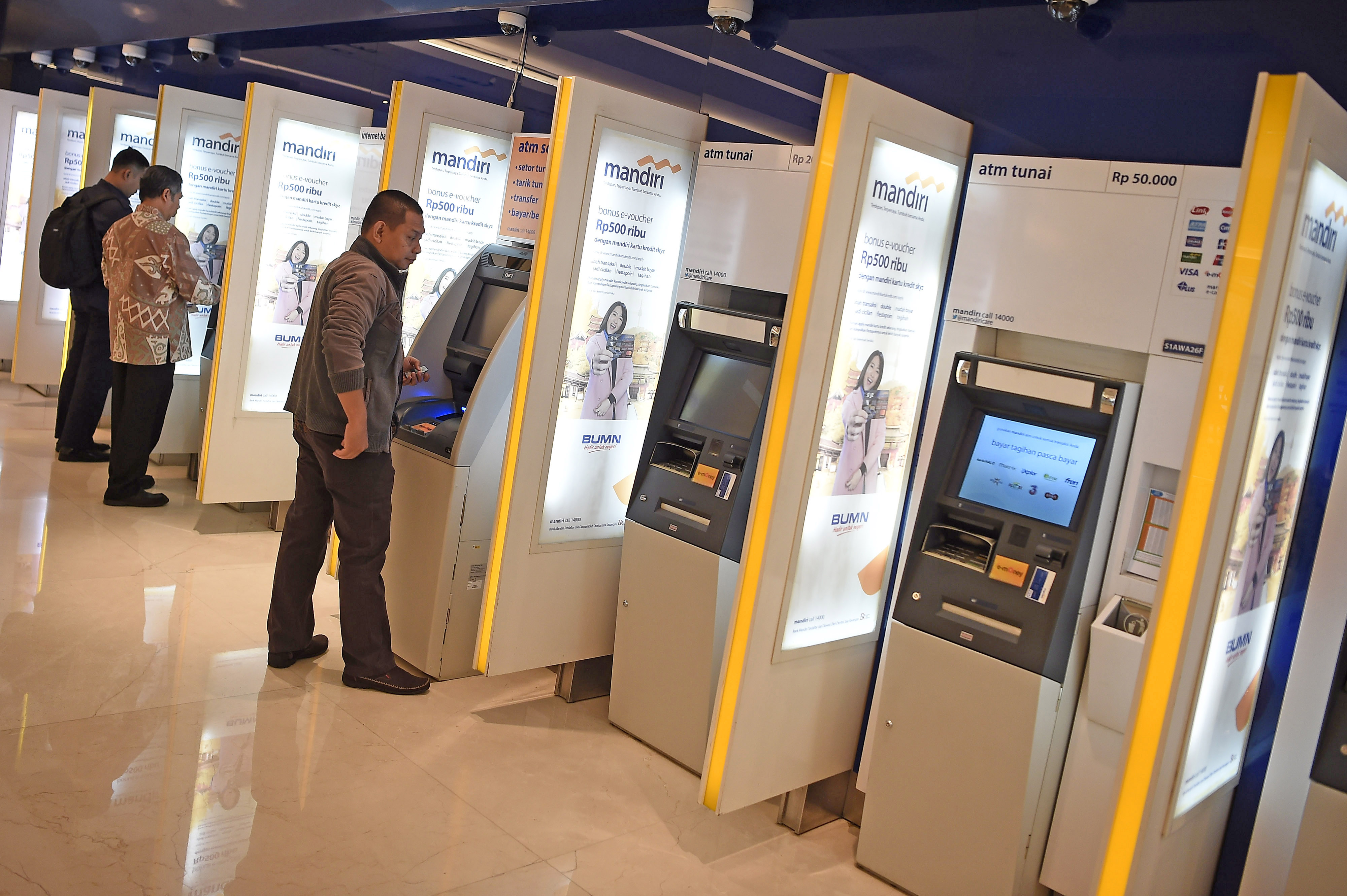 Nasabah bertransaksi di anjungan tunai mandiri (ATM) Bank Mandiri, Jakarta.
