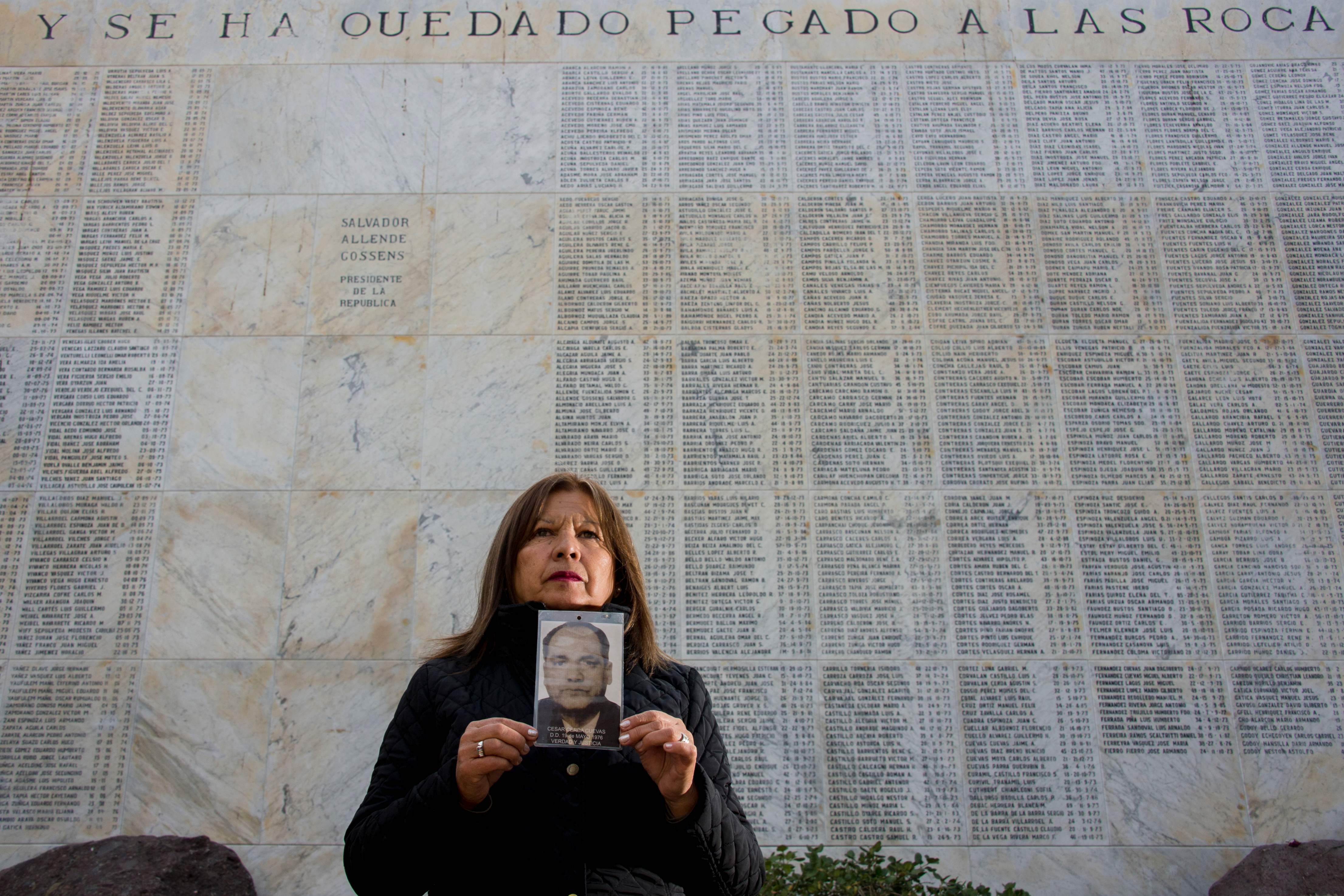 Juana Cerda, putri dari Cesar Cerda memegang foto ayahnya.  Cerda satu dari ribuan orang yang diculik rezim diktator Augusto Pinochet.