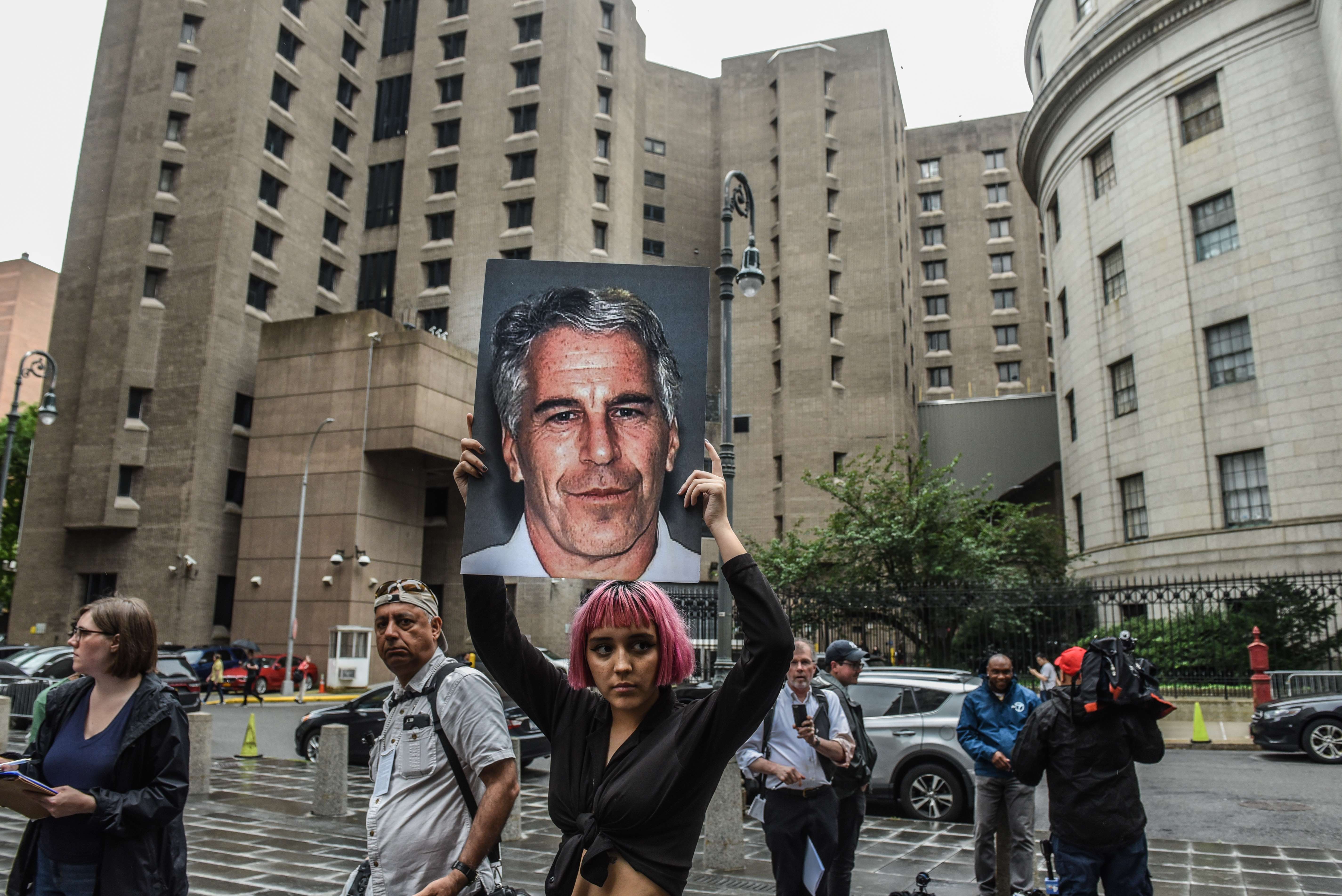 Perempuan muda membawa poster Jeffrey Epstein, di depan Pengadilan Federal New York Juli 2019. 