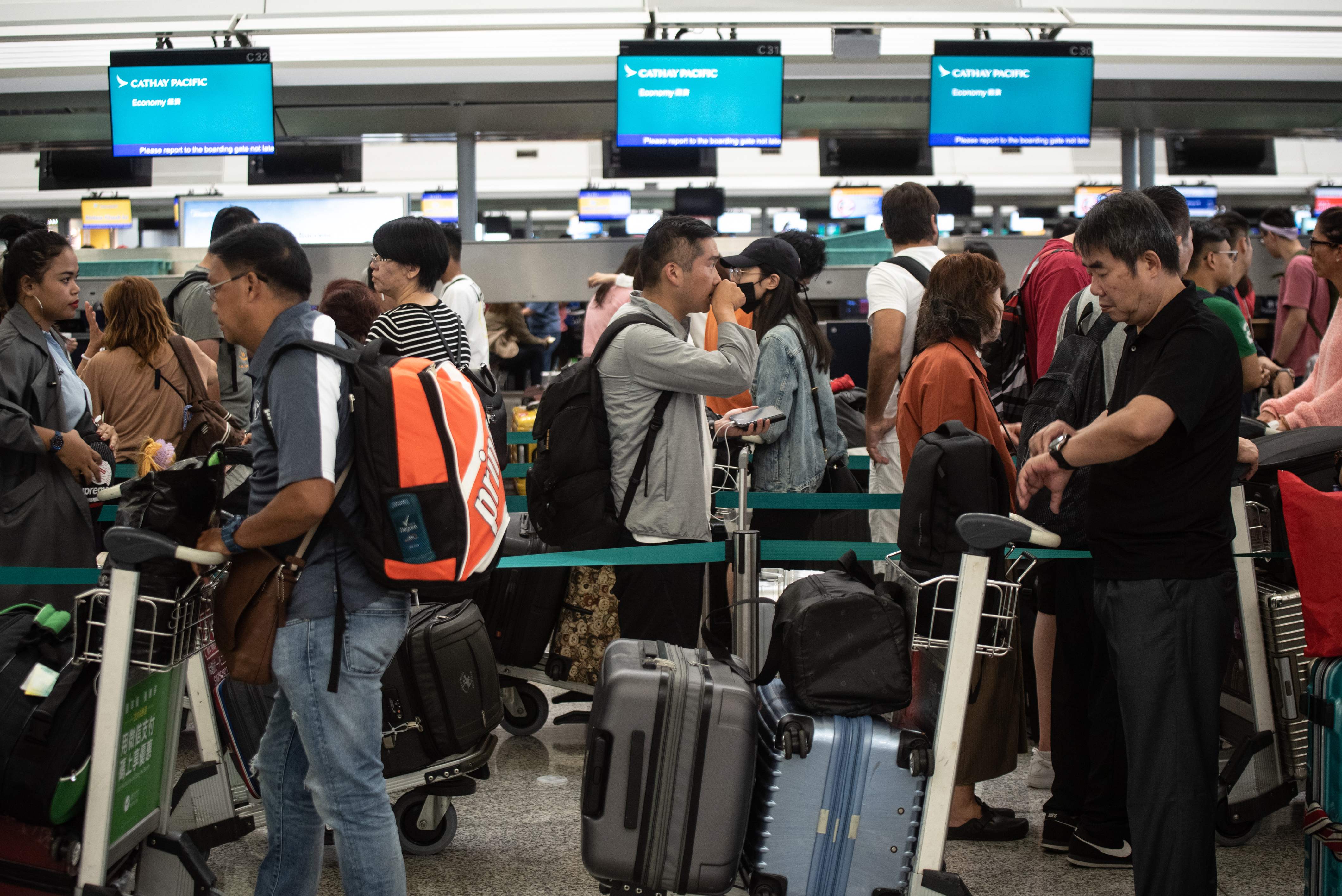 Sejumlah calon penumpang mengantre di konter check-in Bandara Hong Kong