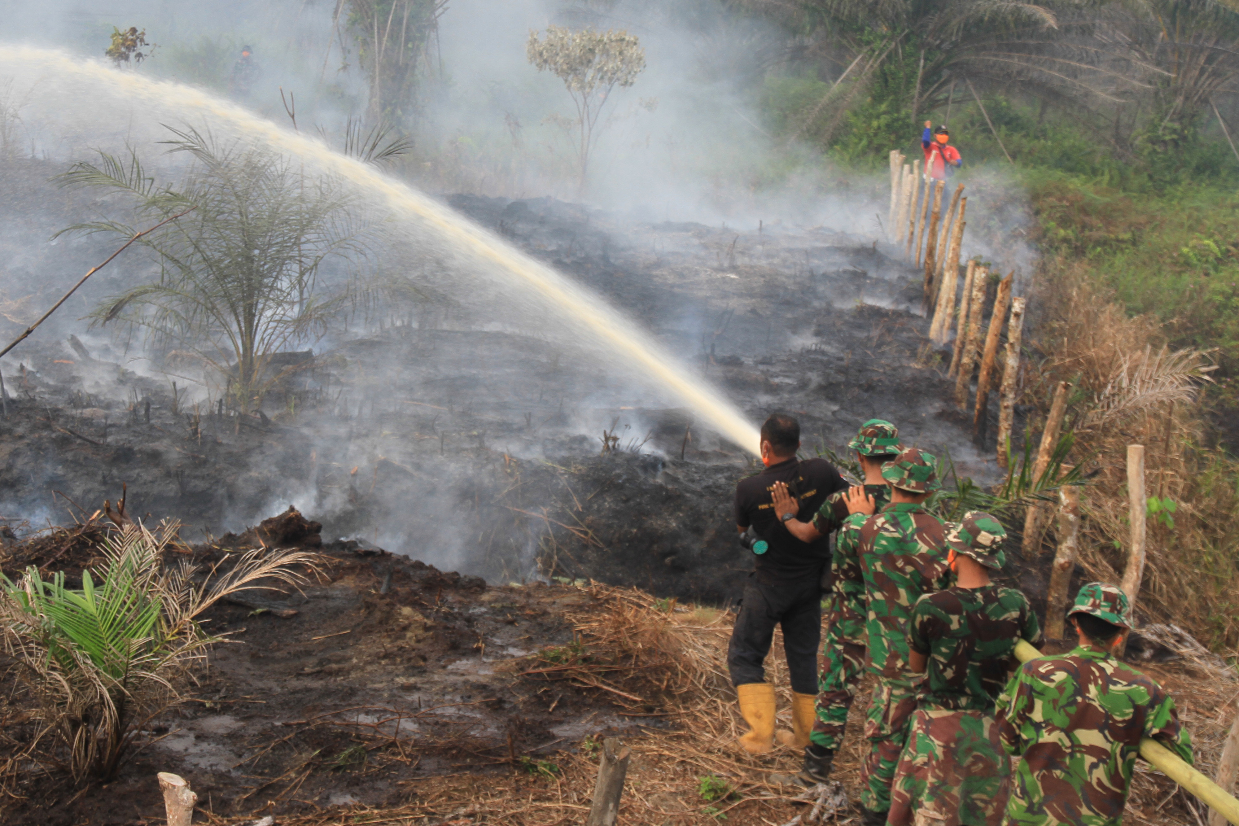 Petugas gabungan berusaha memadamkan api yang membakar lahan gambut di Desa Ujong Tanoh Darat, Meureuboe, Aceh Barat.