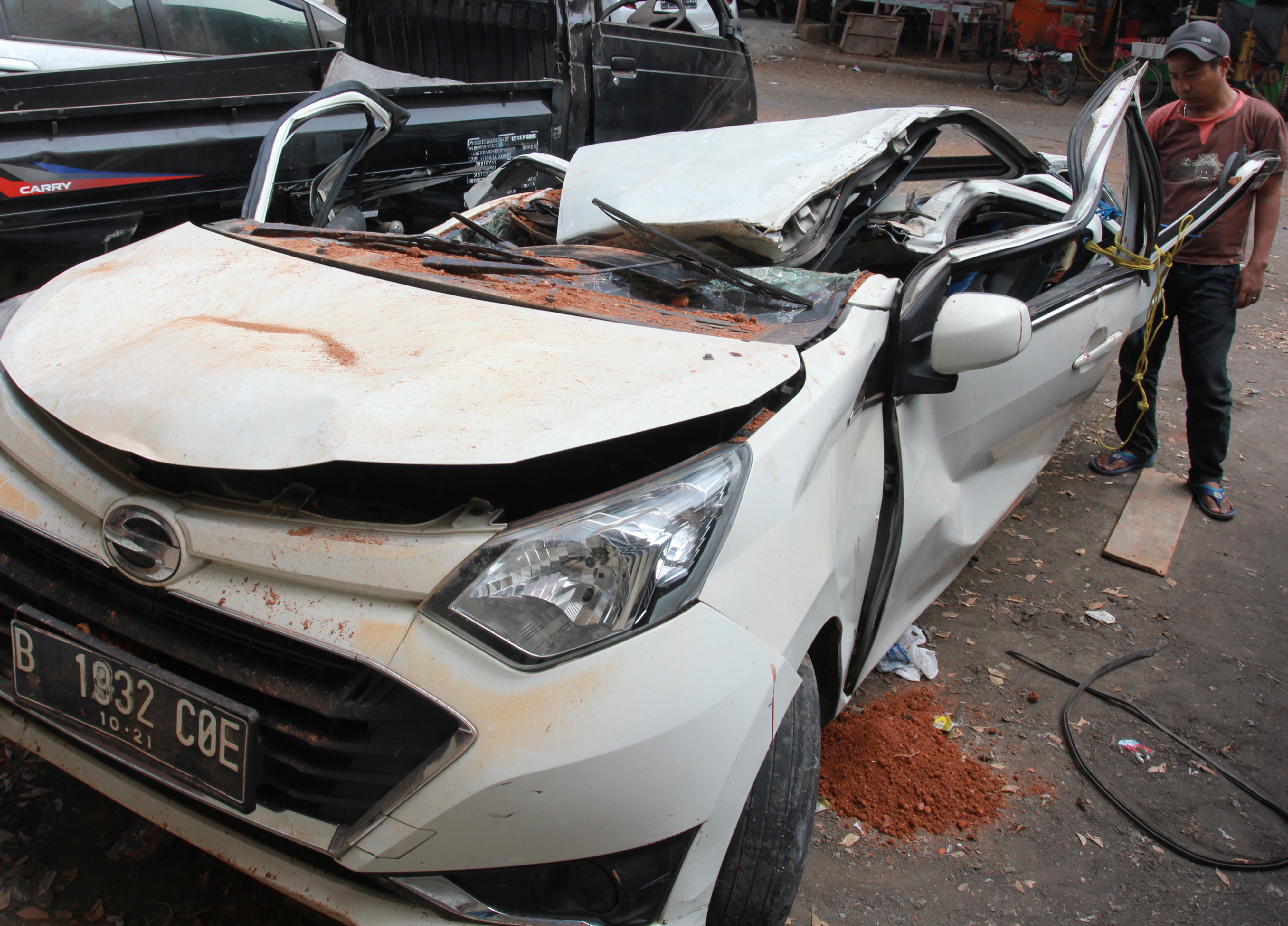 Warga melihat bangkai mobil kecelakaan maut yang hancur tertindih badan truk di Karawaci, Tangerang, Banten, Kamis (1/8). 