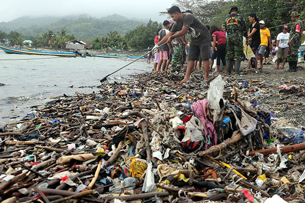 Sejumlah warga mengangkat sampah saat melakukan Aksi Bersih Pantai 