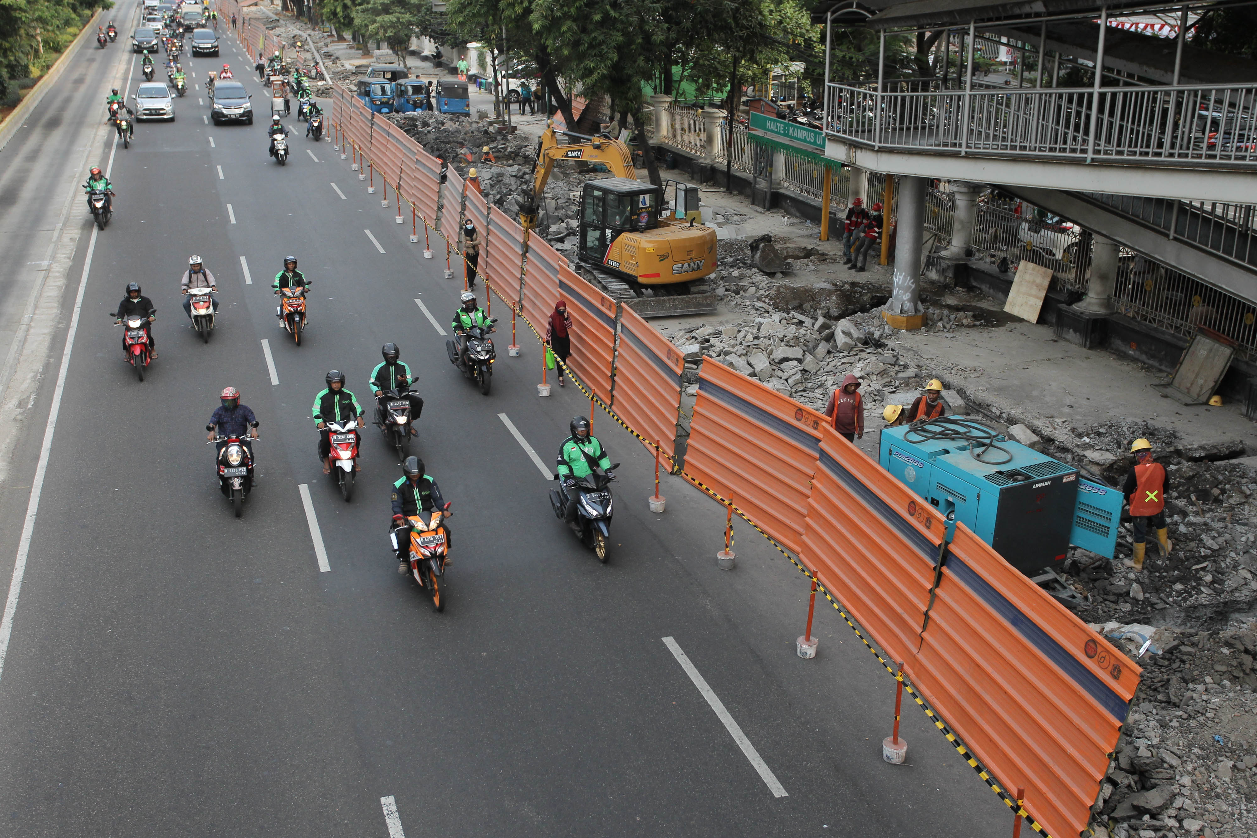Pengendara sepeda motor melintas di proyek revitalisasi trotoar di Jalan Salemba, Jakarta Pusat, Selasa (6/8/2019).