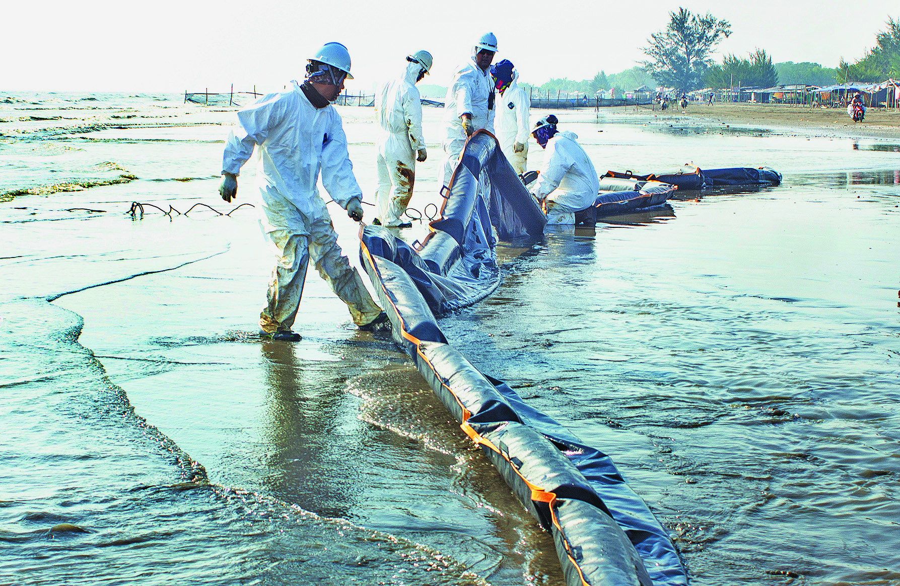 Petugas menyelesaikan pemasangan peralatan Oil Boom milik OSCT untuk melokalisasi tumpahan minyak mentah di Pantai Sedari, Cibuaya, Karawang