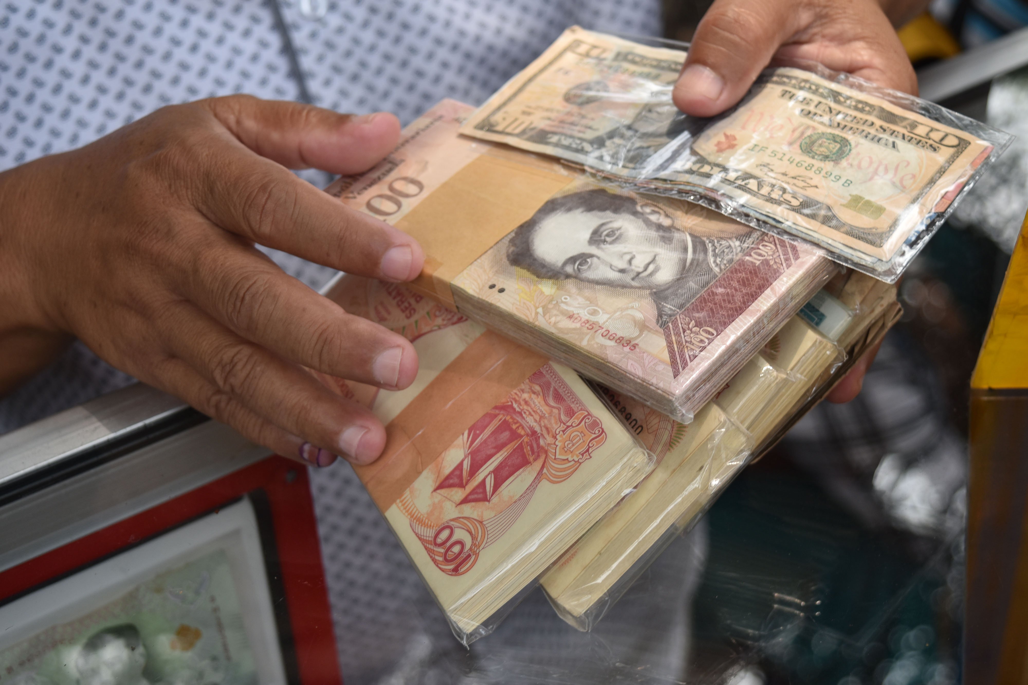 Penyedia jasa tukar uang menata lembaran mata uang rupiah dan mata uang asing di Taman Topi, Bogor, Jawa Barat