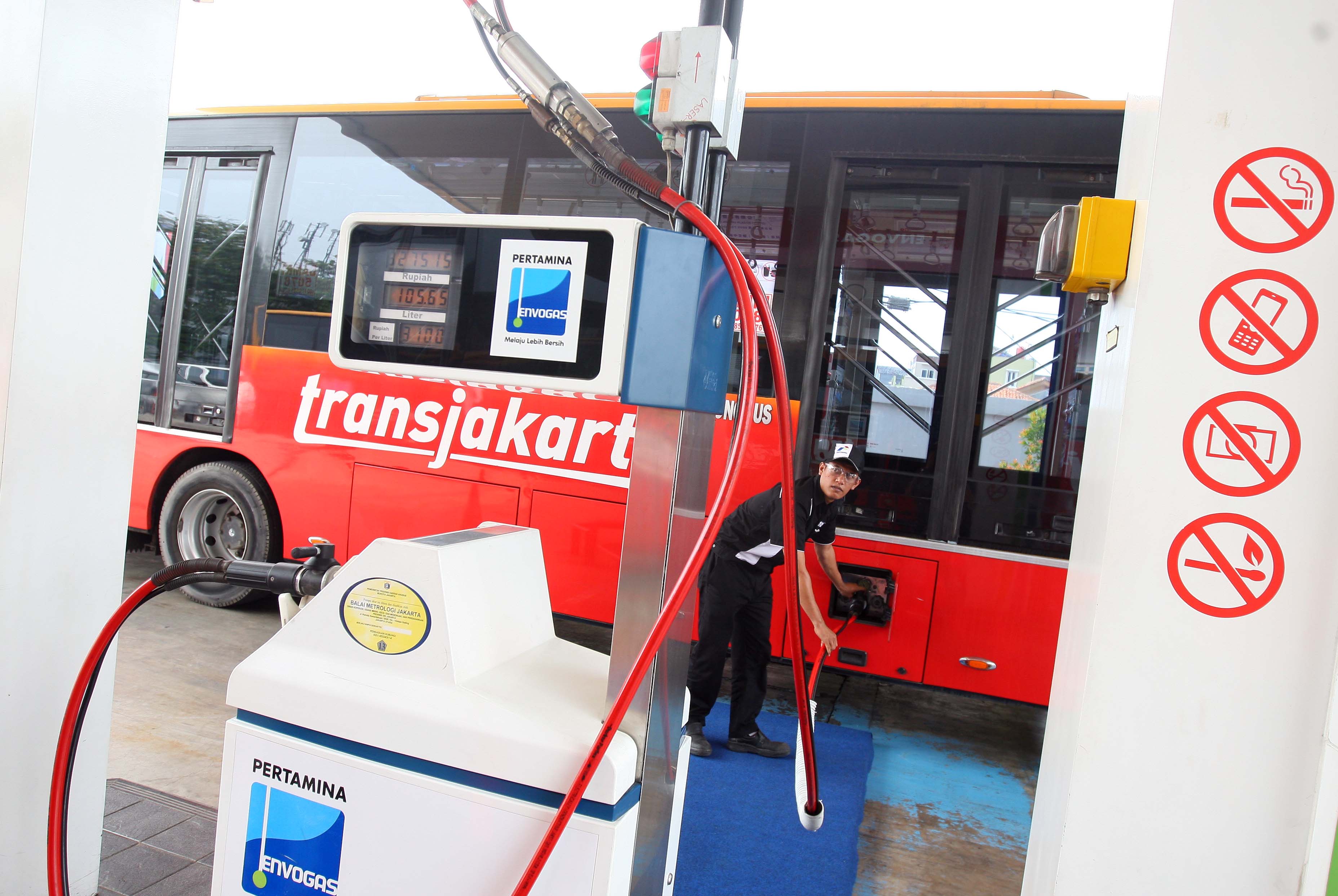 Petugas mengisi bahan bakar gas ke bus TransJakarta