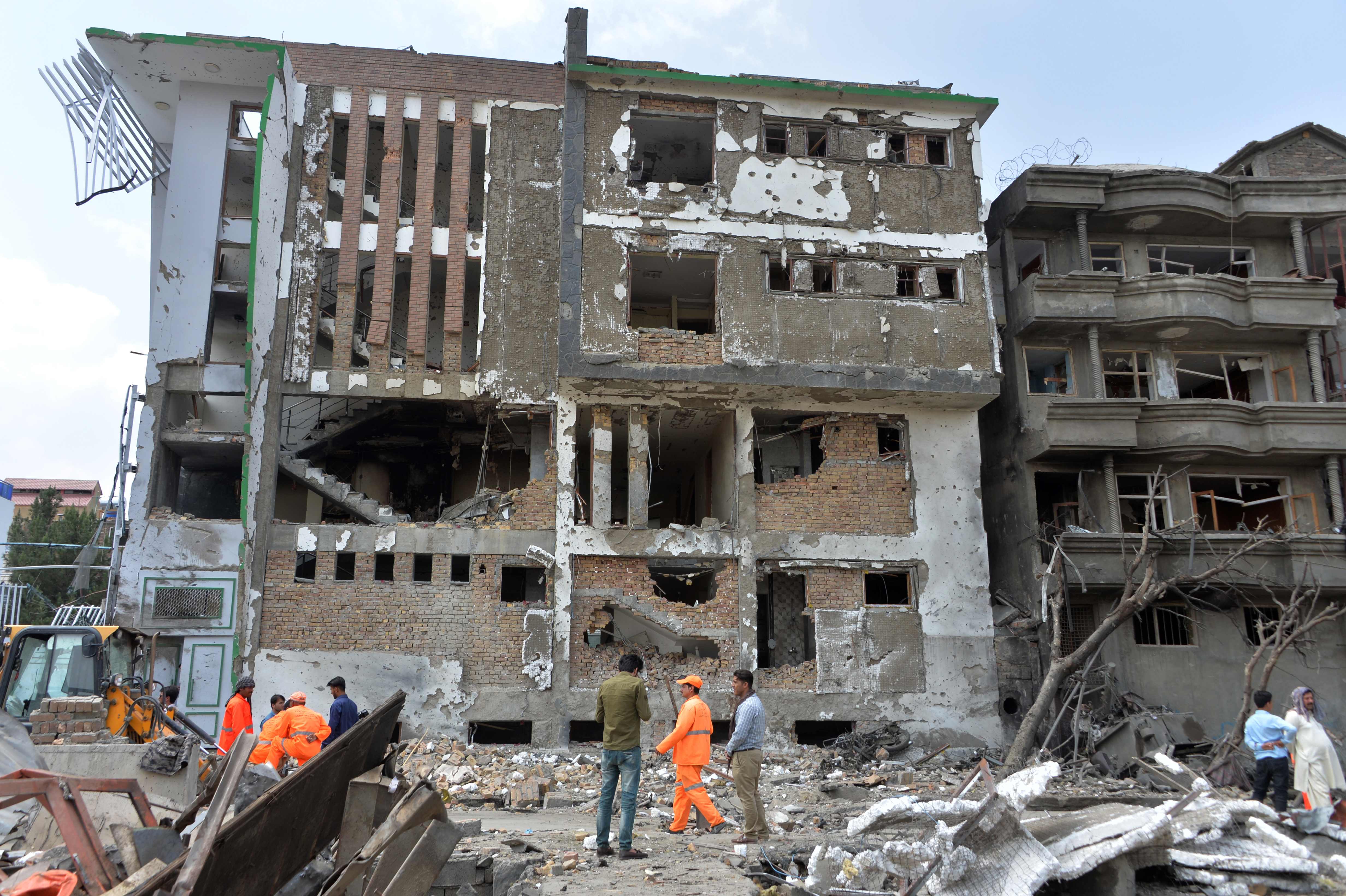 Pasukan keamanan Afghanistan dan pekerja kota berkumpul di lokasi serangan di Kabul pada 29 Juli 2019, sehari setelah serangan mematikan 