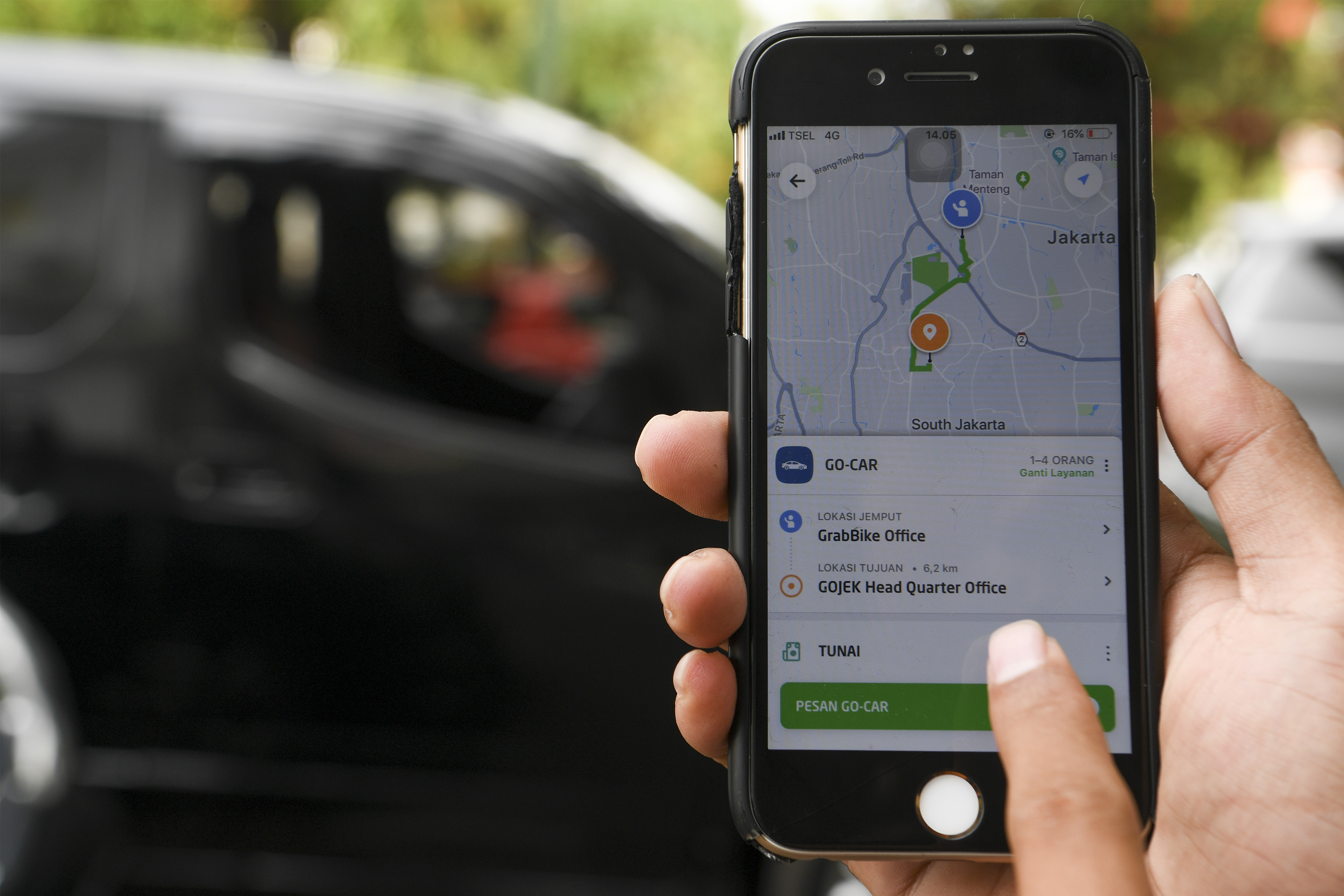 Warga menggunakan aplikasi untuk memesan taksi berbasis dalam jaringan (online) di Jakarta.