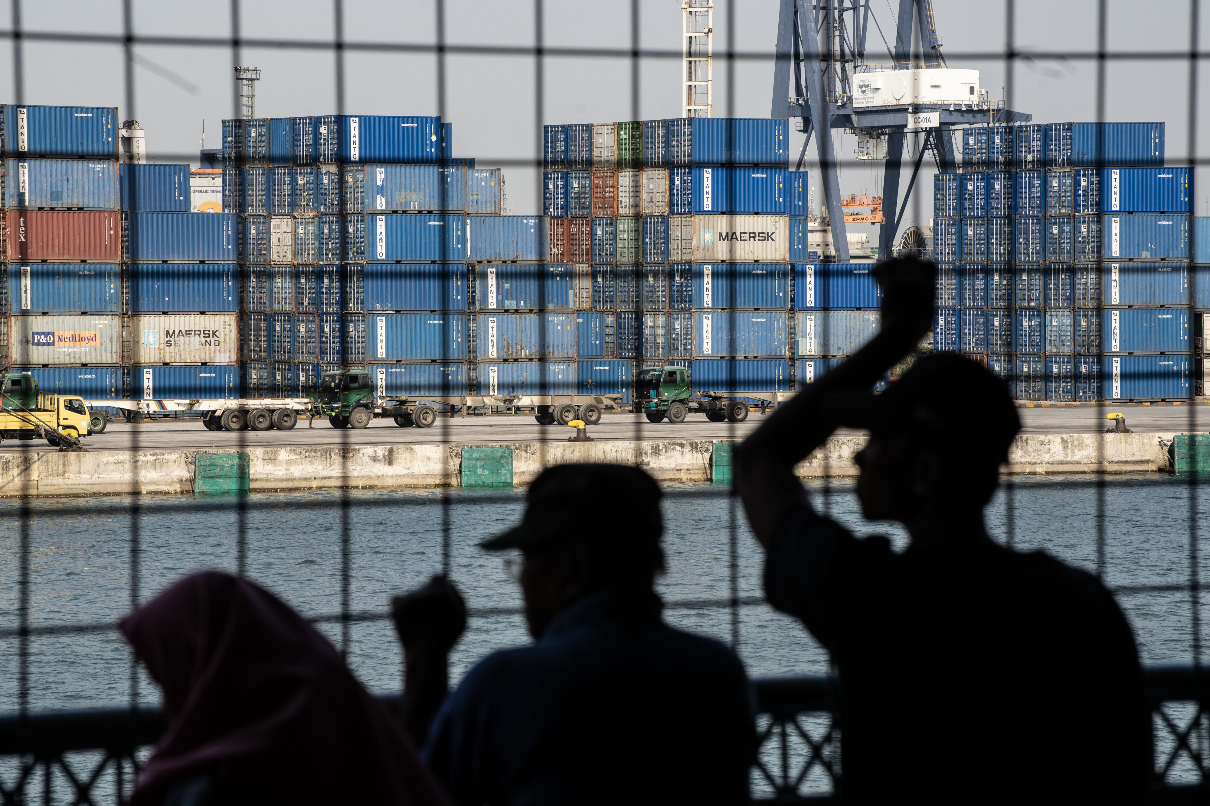 Warga melihat aktivitas bongkar muat peti kemas di Pelabuhan Tanjung Priok, Jakarta