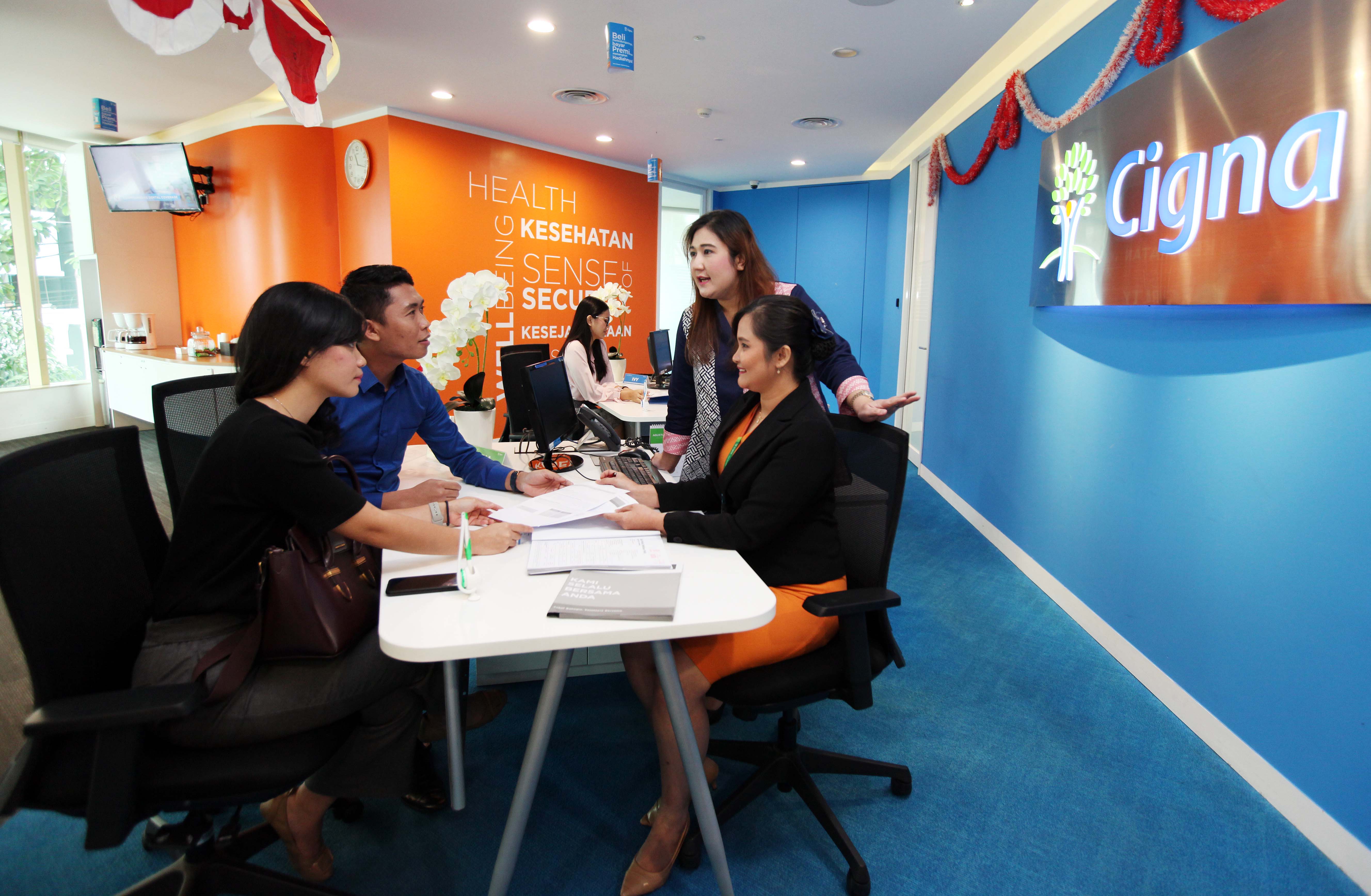Director and Chief Distribution Officer Cigna Indonesia Dini Maharani (kedua kanan)  membantu proses klaim yang sedang diajukan nasabah.