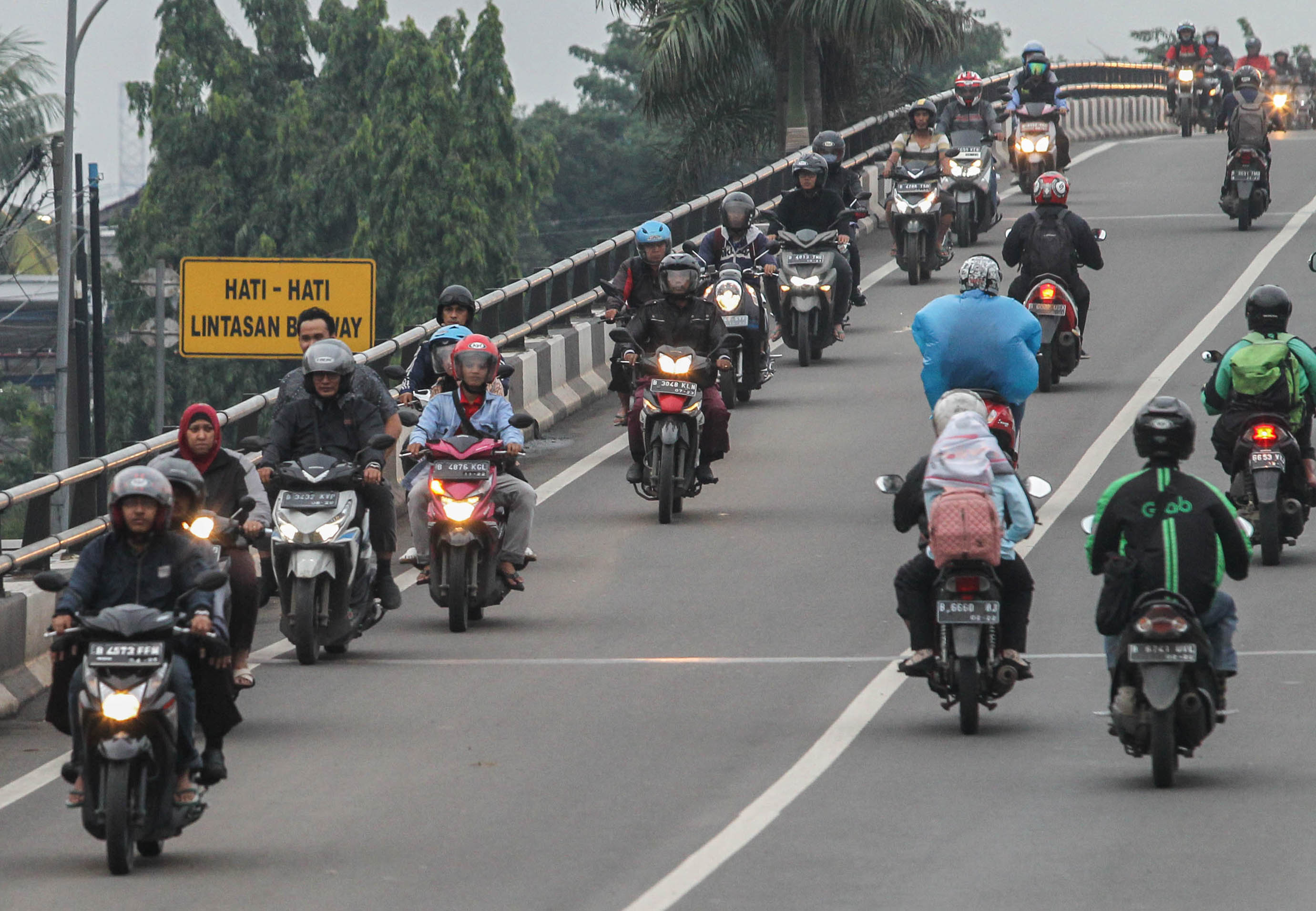 Puluhan pengendara sepeda motor melintas melawan arah di jembatan layang Buaran, Jakarta.