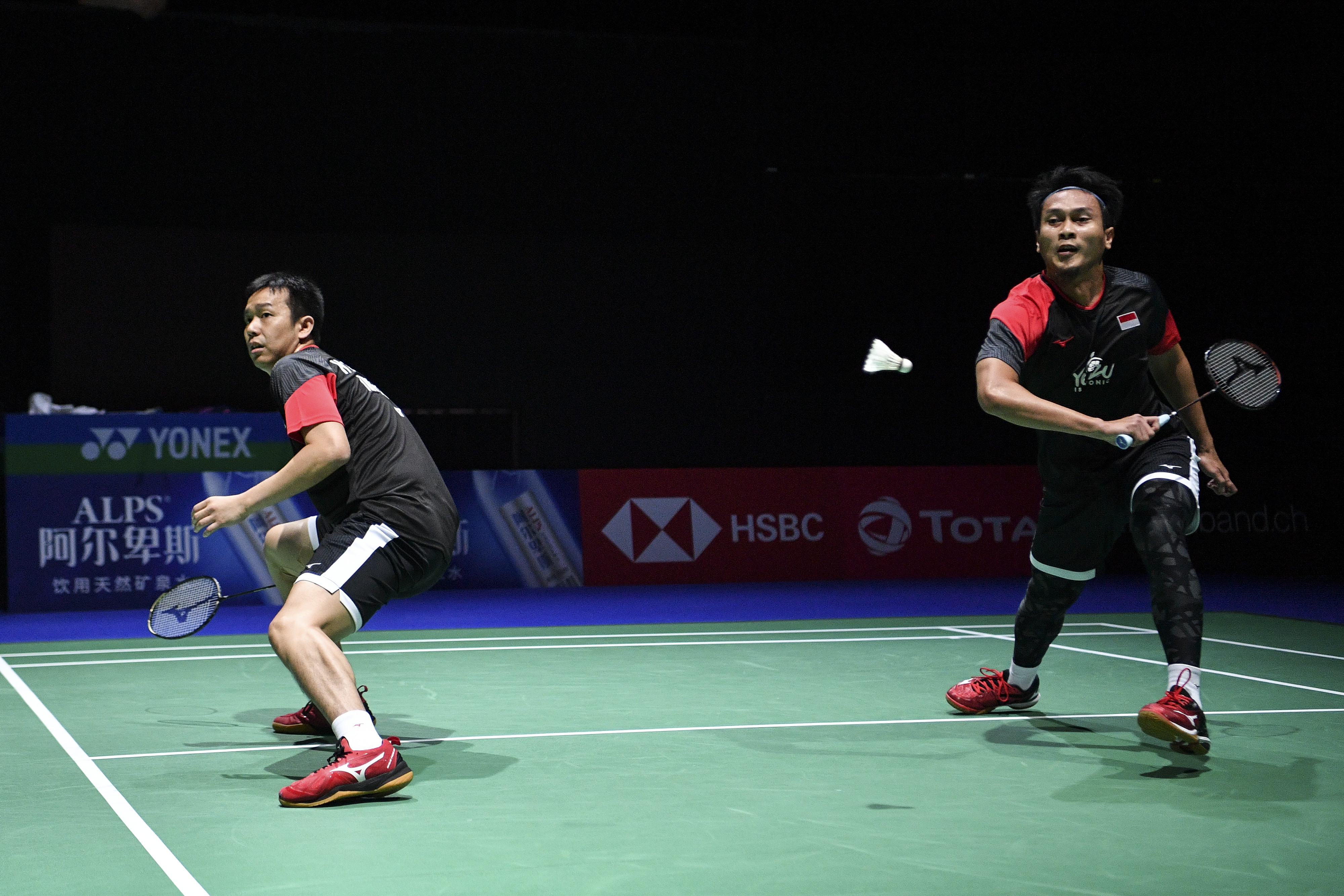 Ganda putra Indonesia Mohammad Ahsan (kanan) dan Hendra Setiawan berusaha mengembalikan kok.