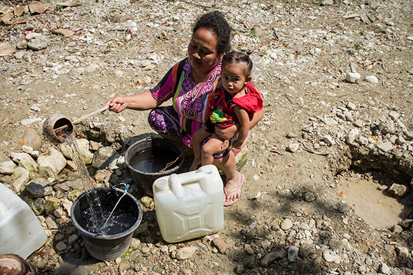 Warga mengambil air dari lubang yang digali di dasar sungai yang kering akibat musim kemarau